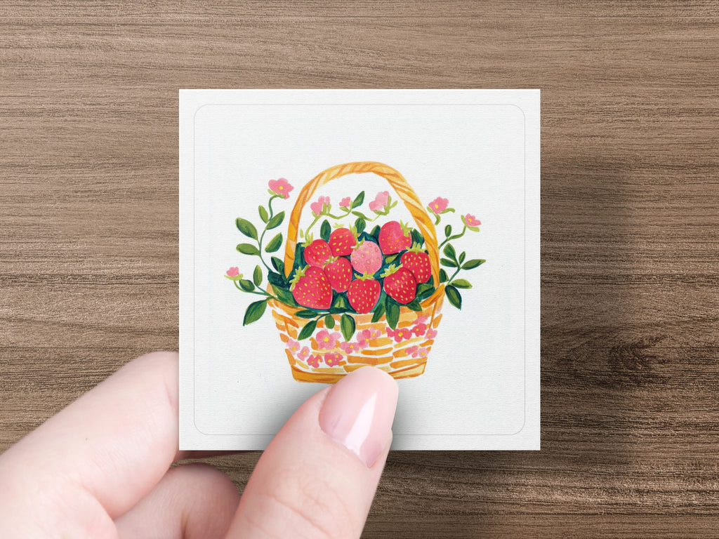 Basket of fresh strawberries with pink flowers and green leaves.