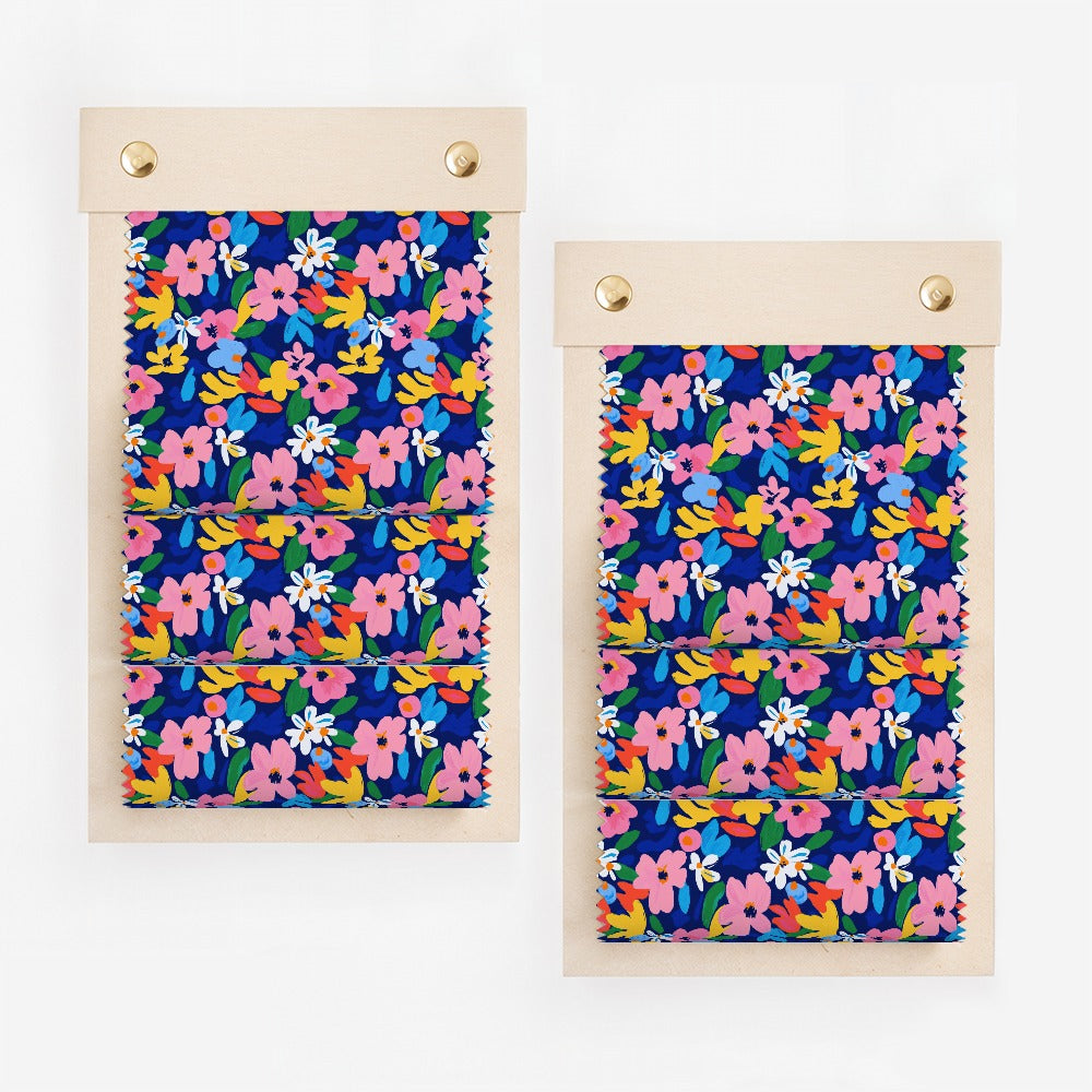 Two fabric swatches with a colorful floral pattern on a dark blue background.