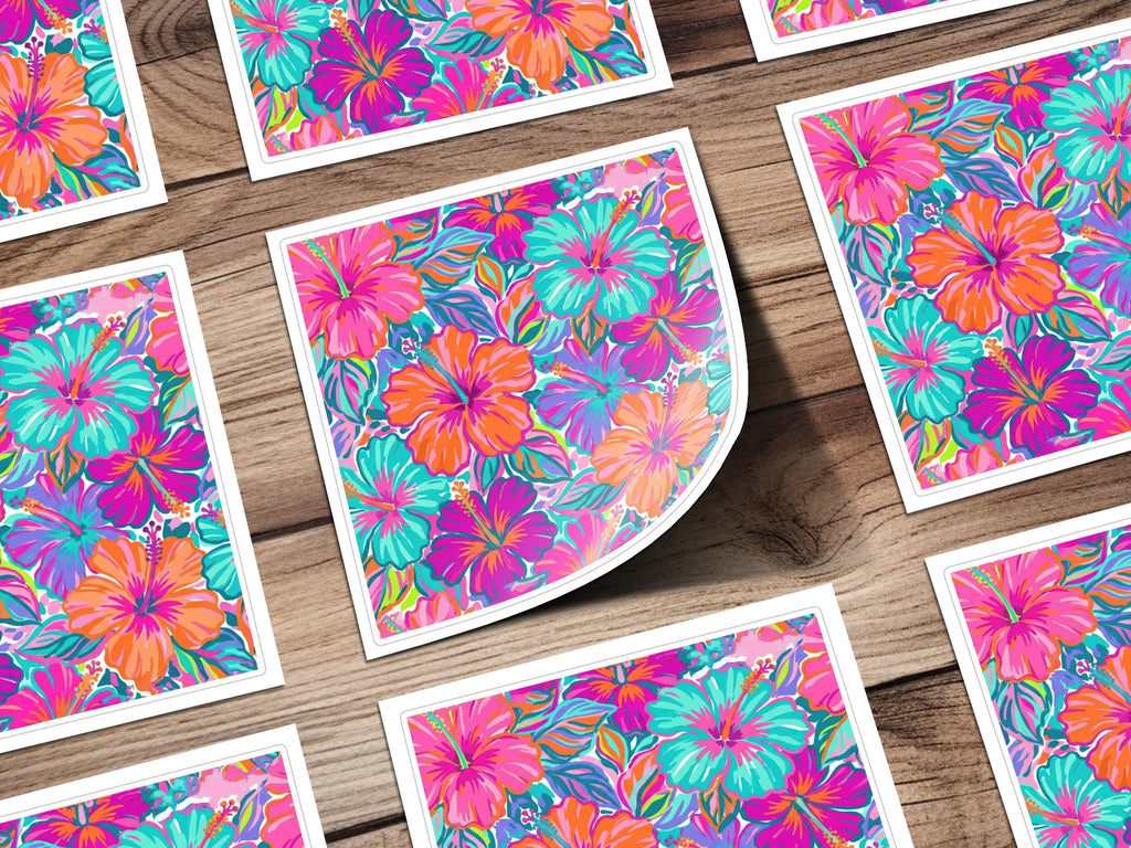 Multiple square cards featuring a vibrant hibiscus floral pattern on a wooden surface.
