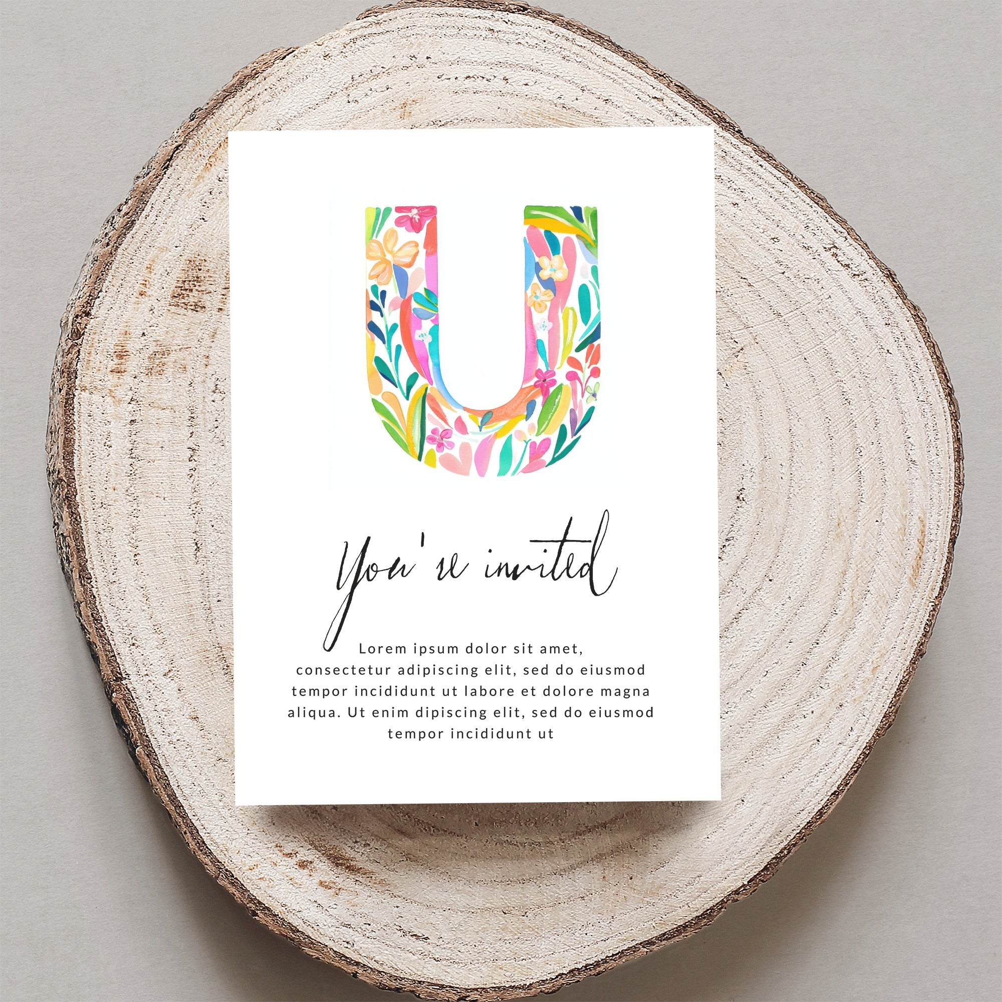 Watercolor letter U on invitation with "You're invited" and placeholder text.
