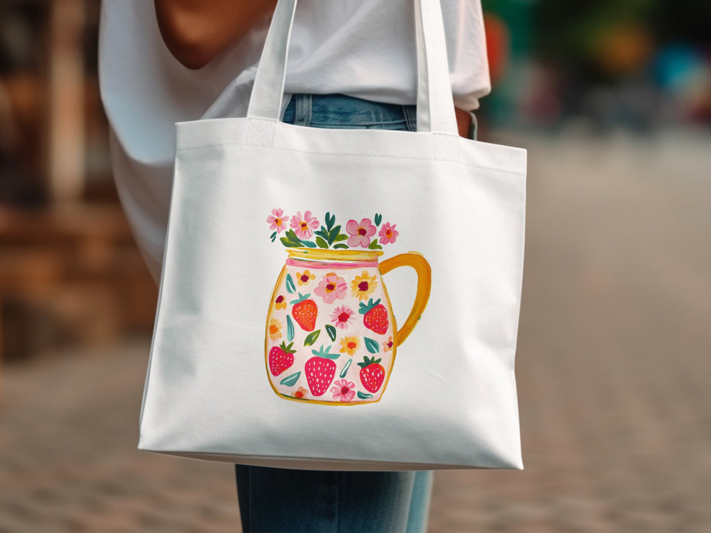 White tote bag with a watercolor design of strawberries and flowers in a mason jar.