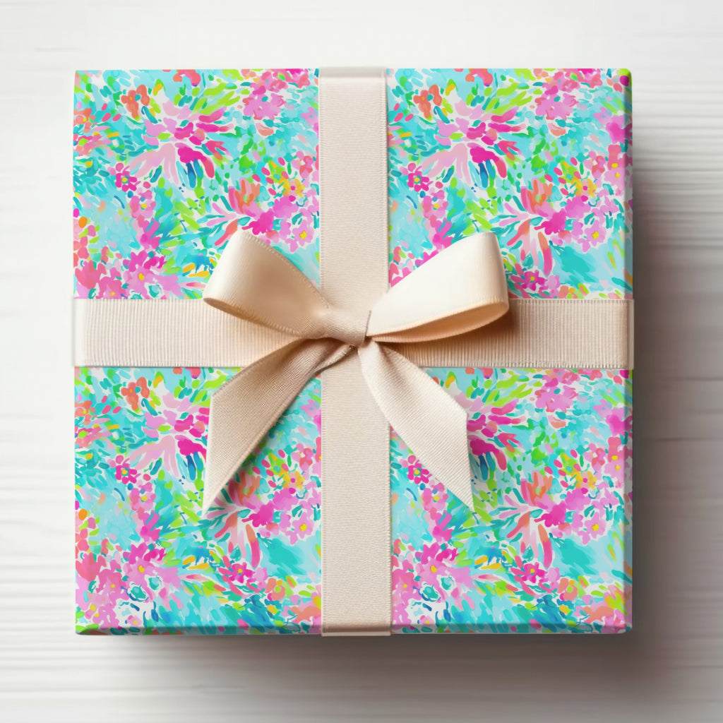 Gift-wrapped box with colorful floral pattern and beige ribbon.
