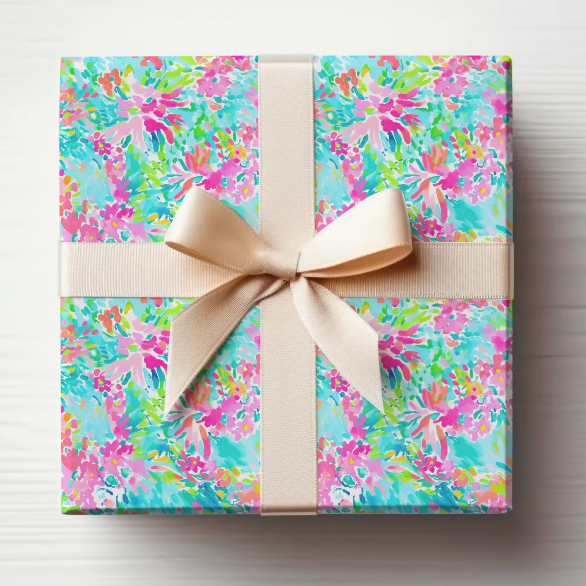 Gift-wrapped box with colorful floral pattern and beige ribbon.