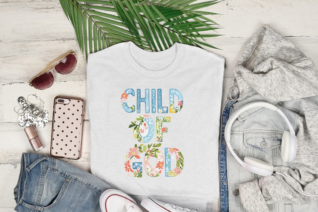 White t-shirt with "Child of God" text surrounded by floral embellishments.