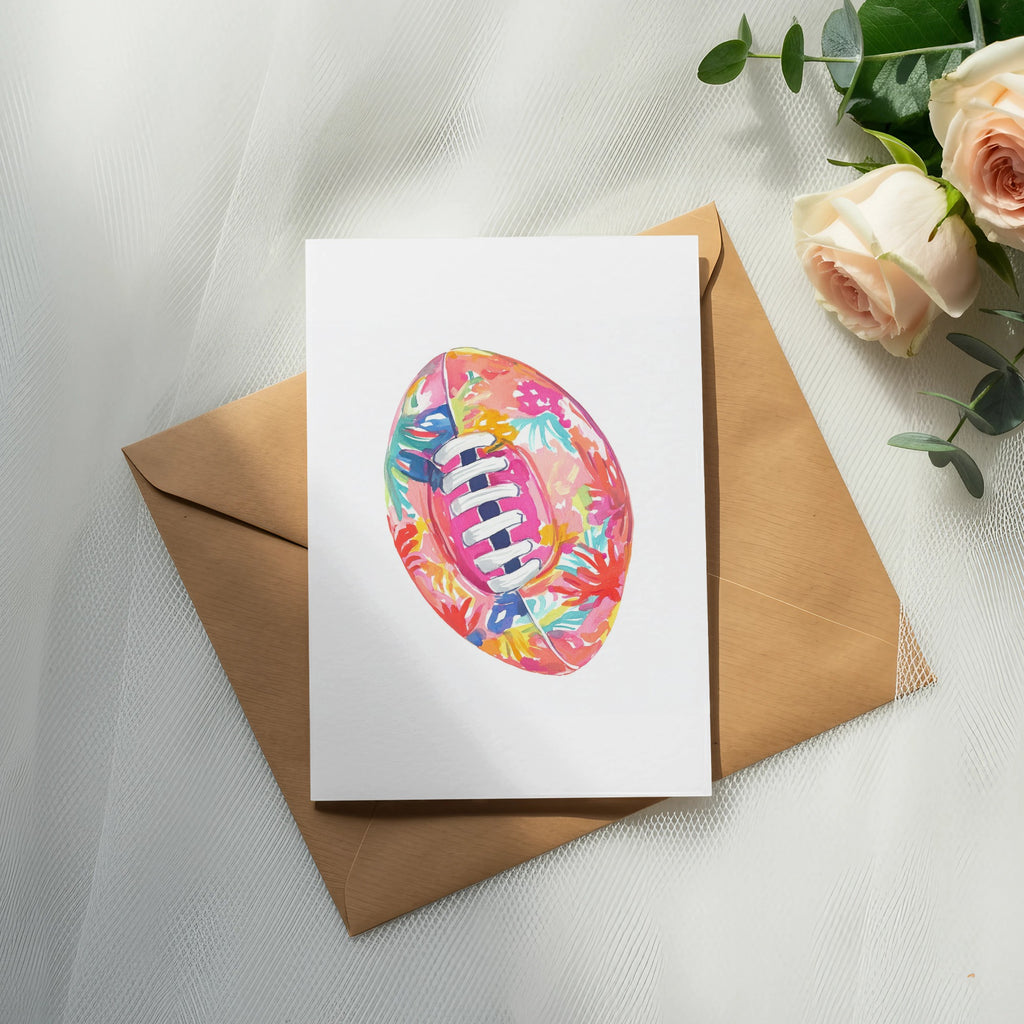Watercolor rugby ball with floral pattern on card over envelope, with roses.