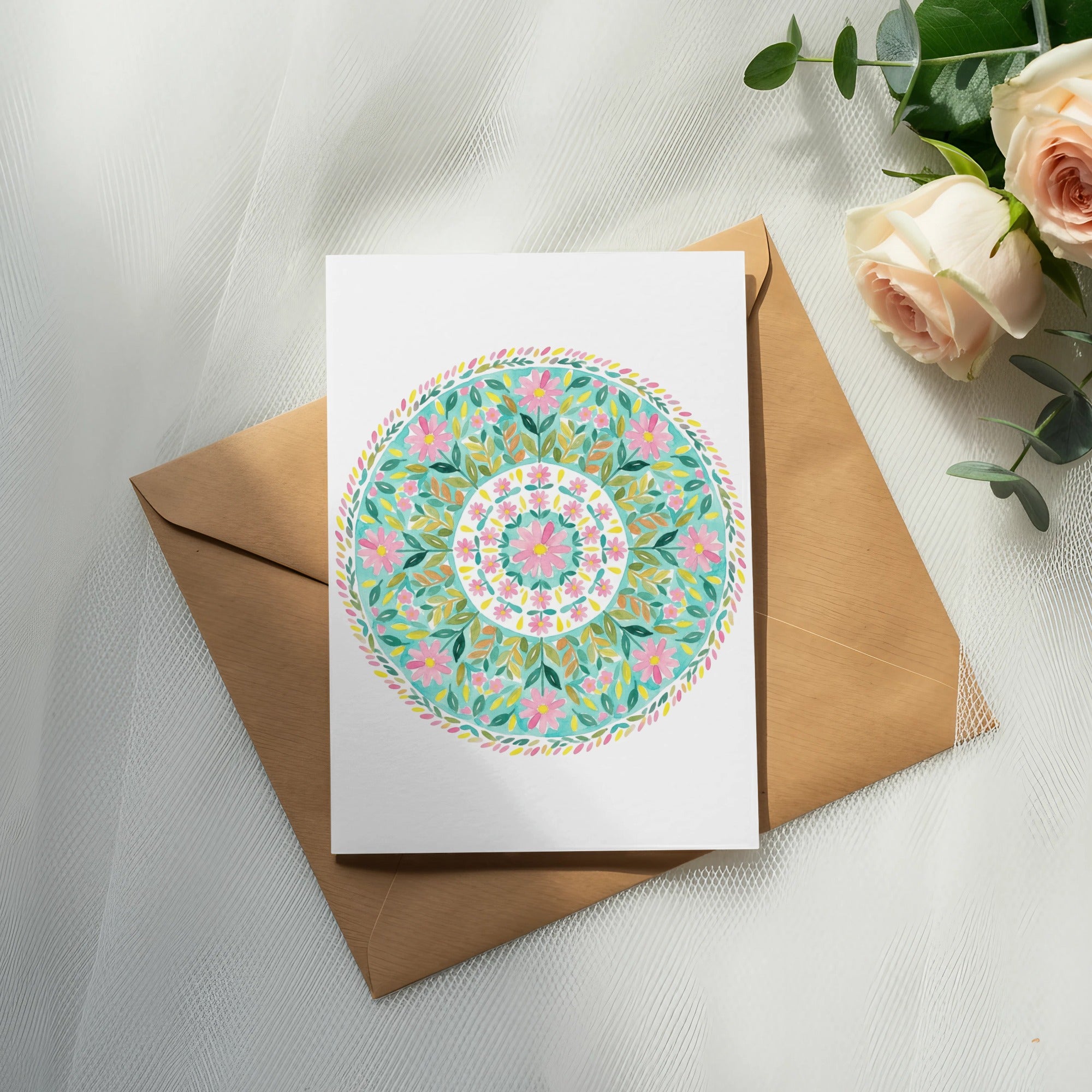 Card with colorful floral mandala design on brown envelope, with roses and eucalyptus.