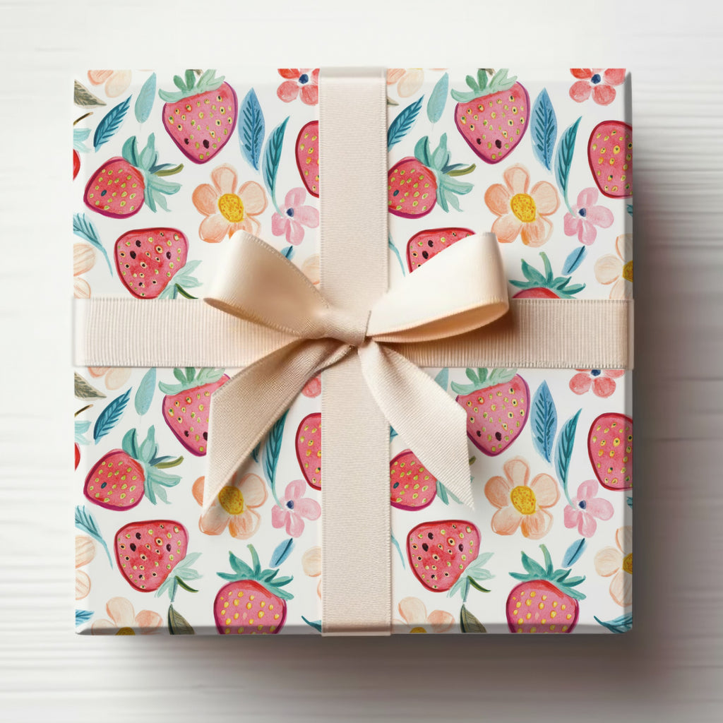 Gift box with strawberry and floral pattern, tied with a light brown ribbon.