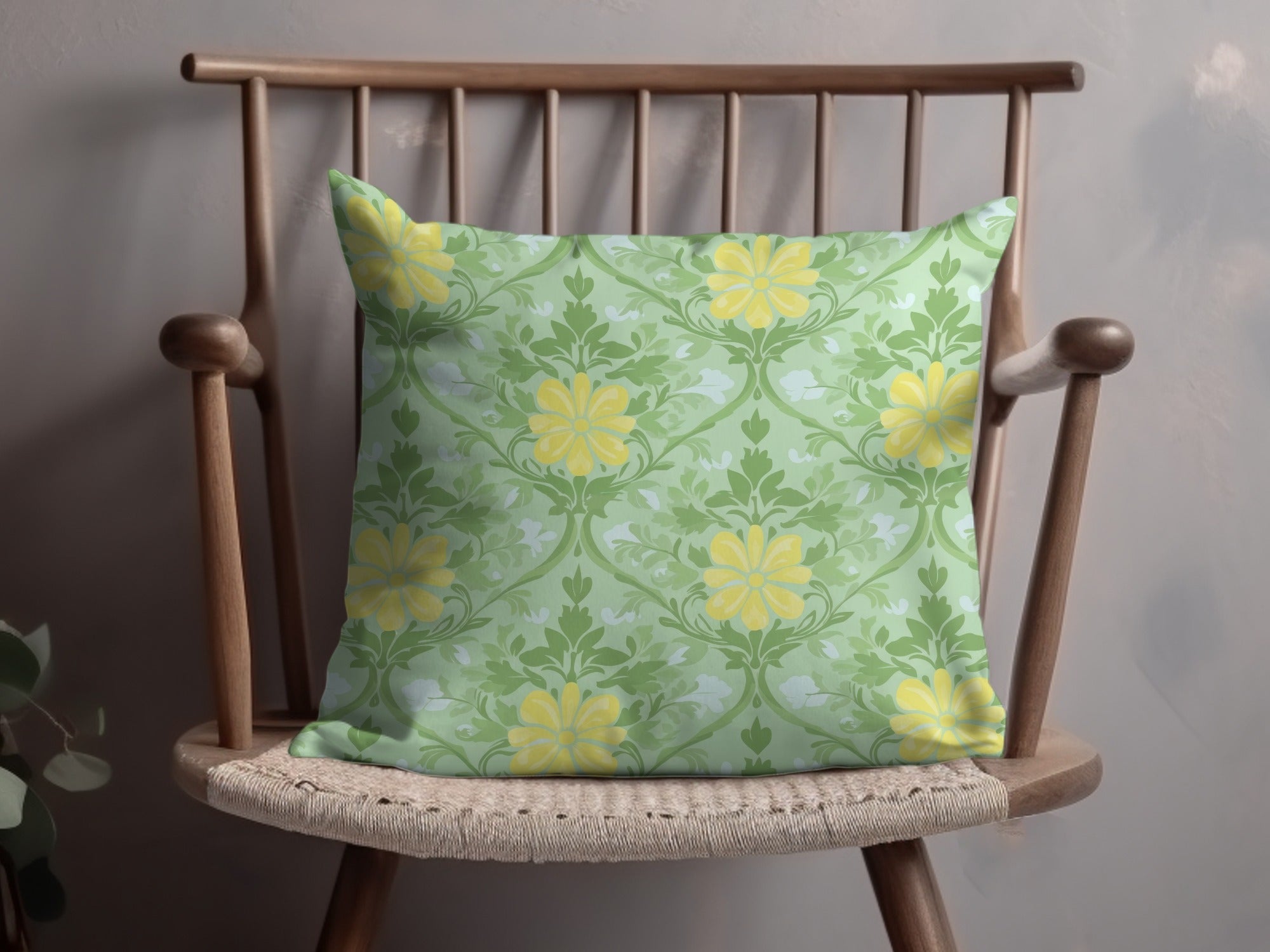 Green throw pillow with yellow floral pattern on a wooden chair.