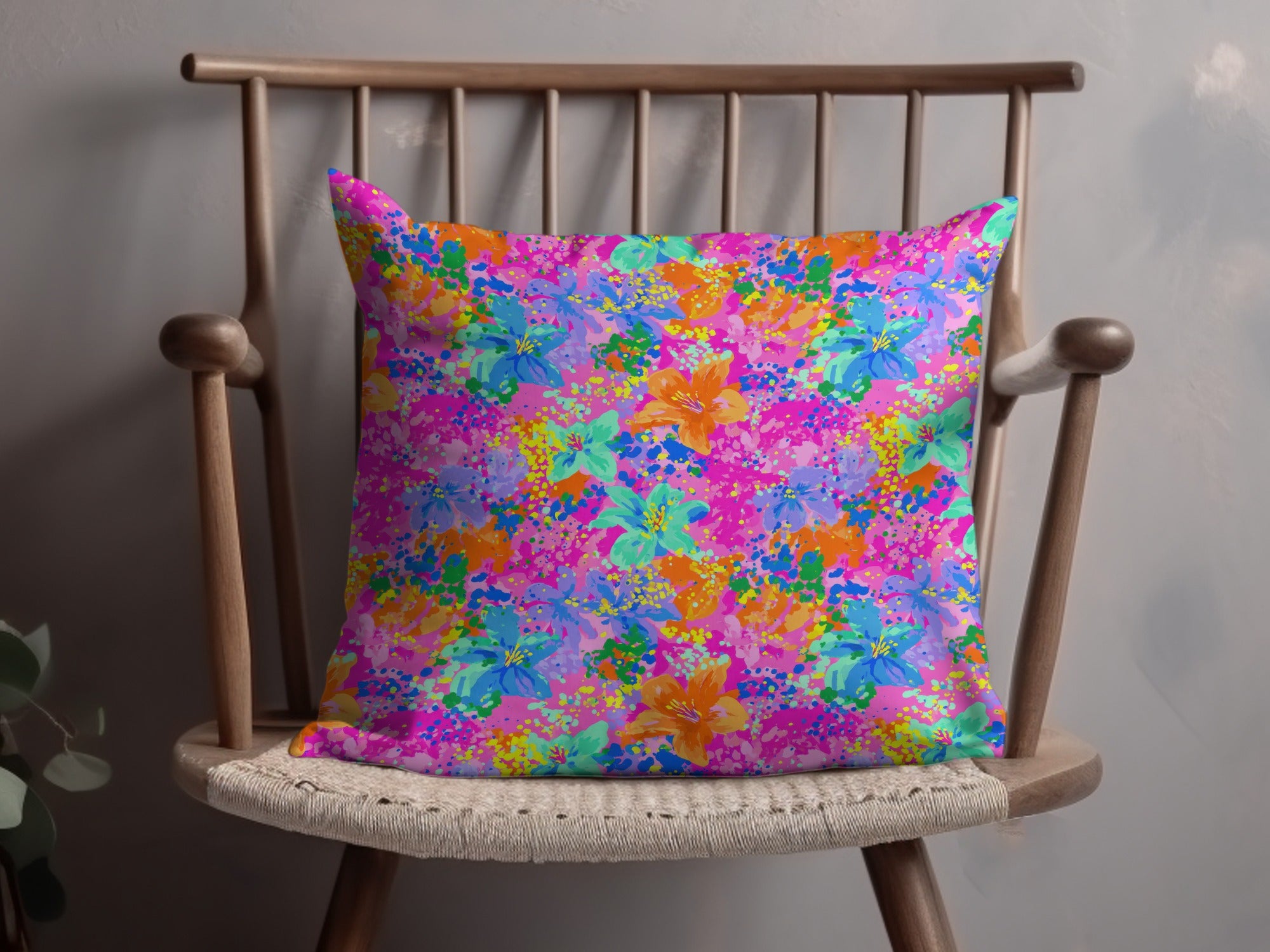 Throw pillow with a vibrant floral pattern on a wooden chair.
