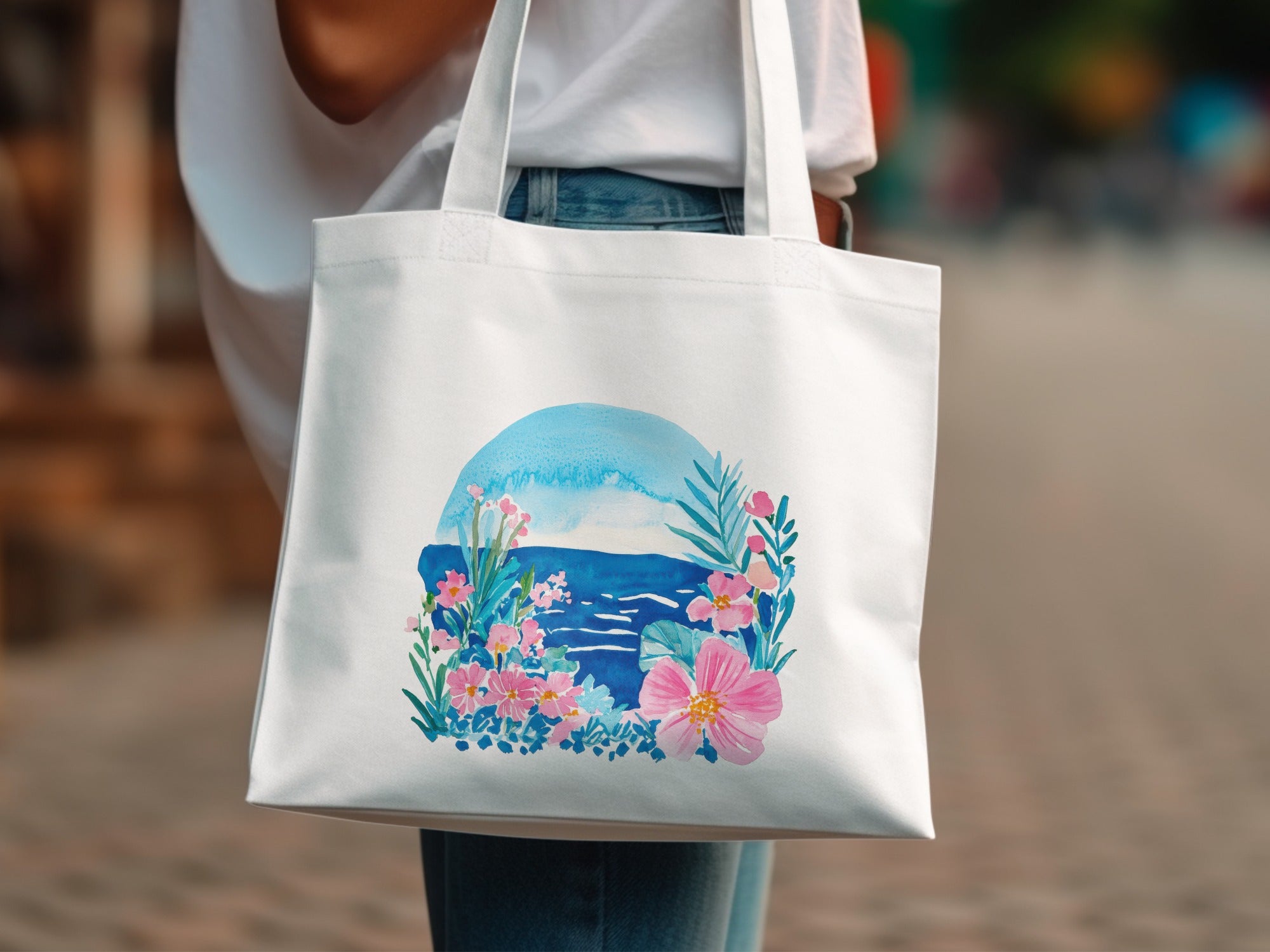 White tote bag with watercolor floral and ocean scene.
