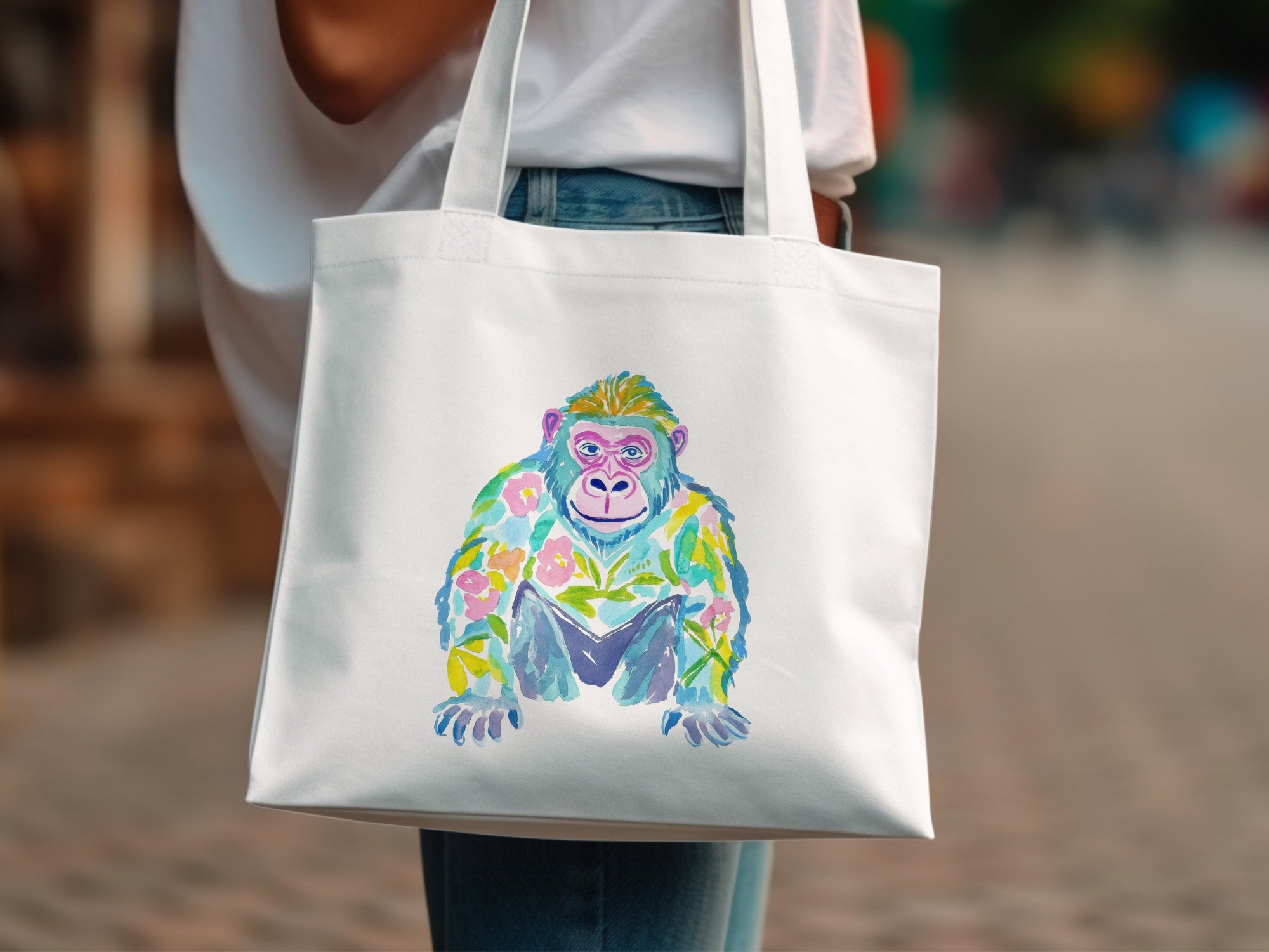 White tote bag with watercolor gorilla design featuring flowers.