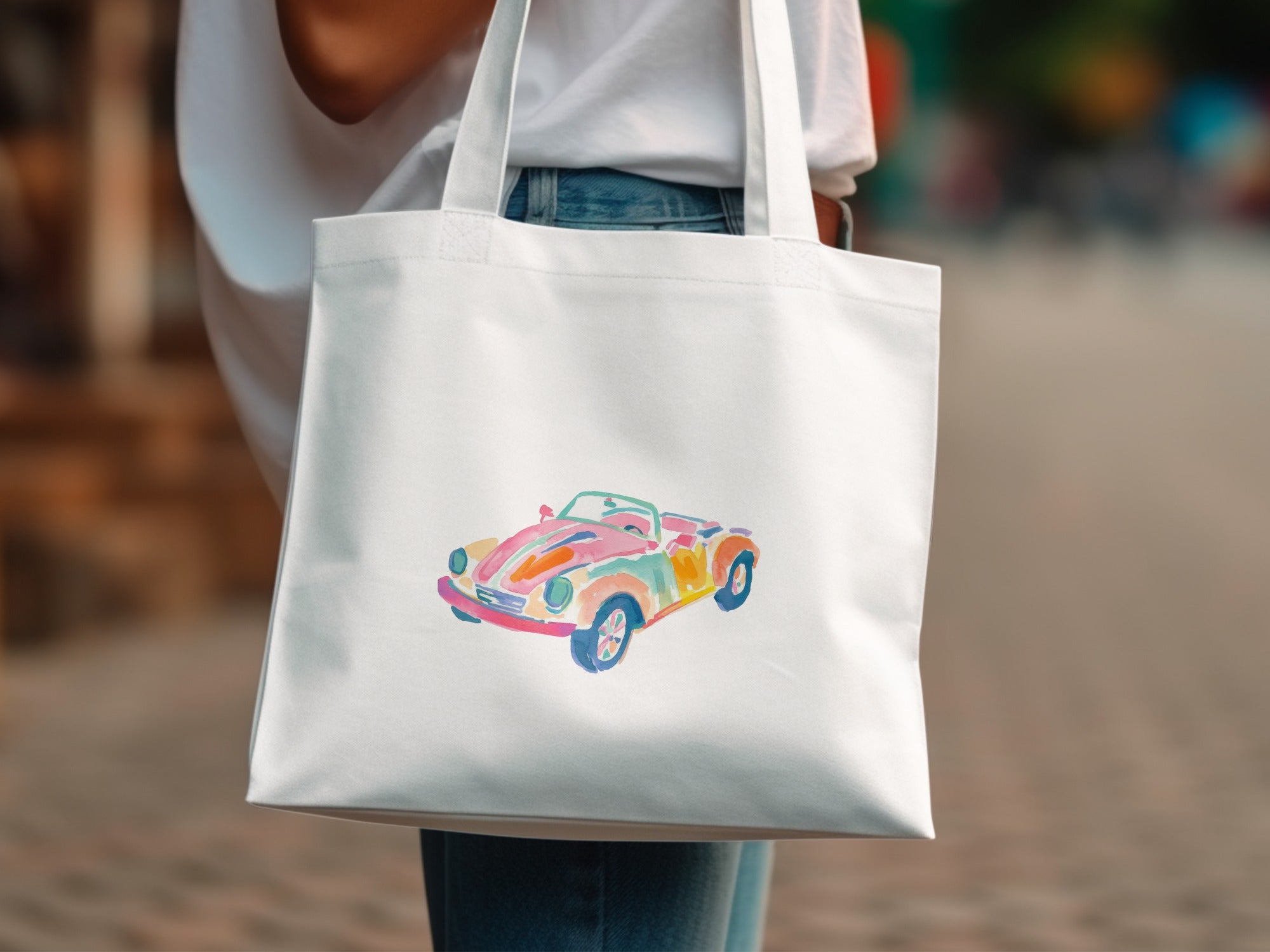 White tote bag with watercolor painting of a colorful convertible car.