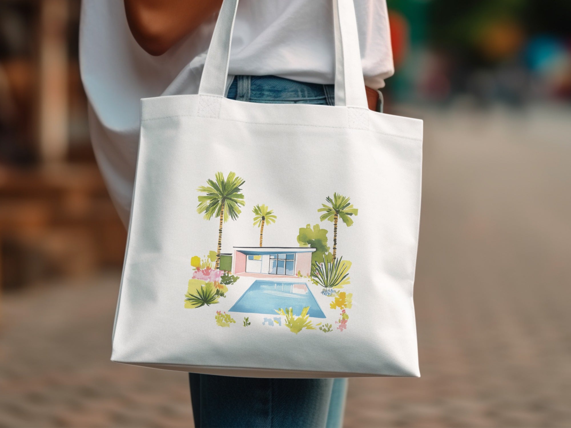 White tote bag with watercolor illustration of a mid-century modern home and pool.