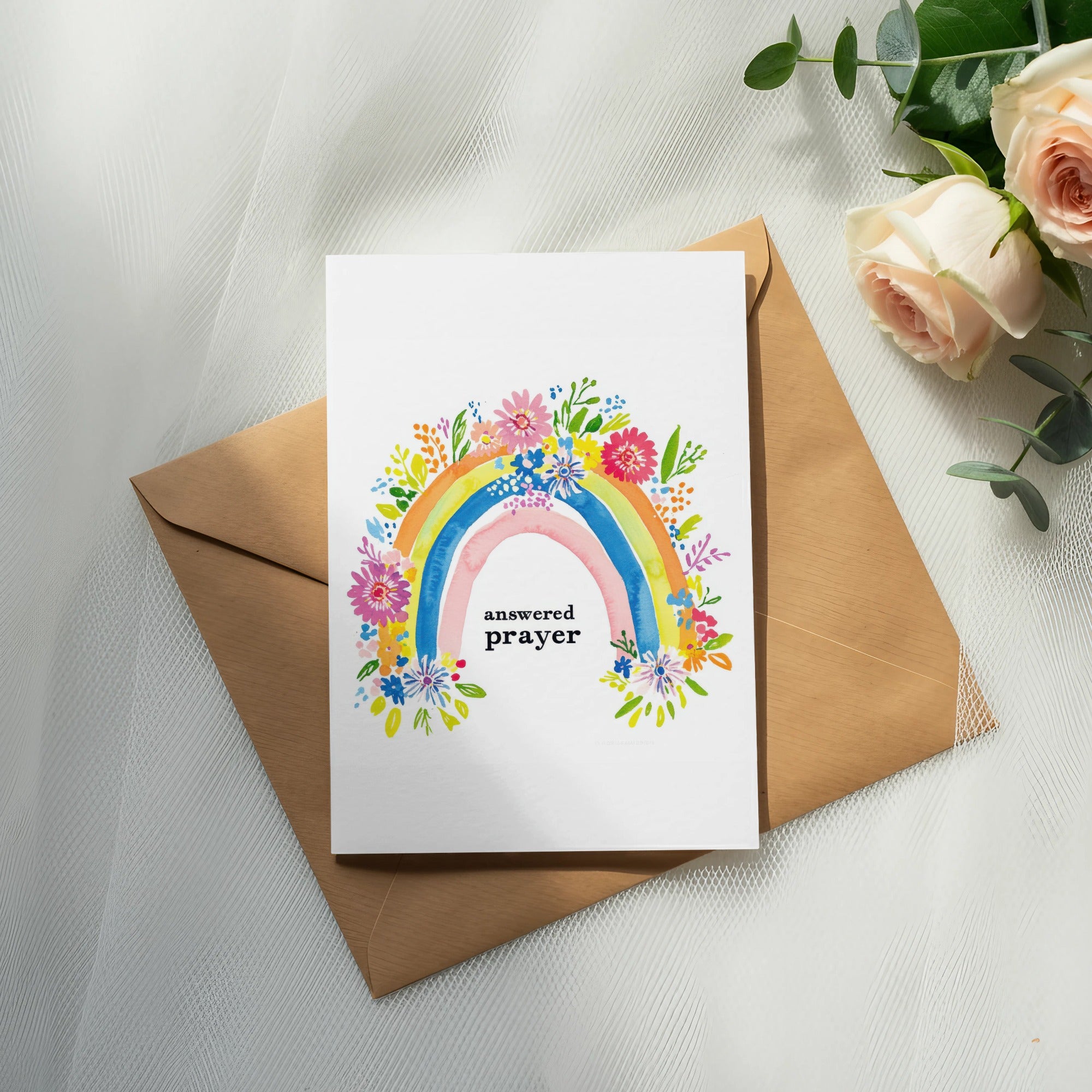Card with rainbow and floral design, text "answered prayer" inside an envelope.