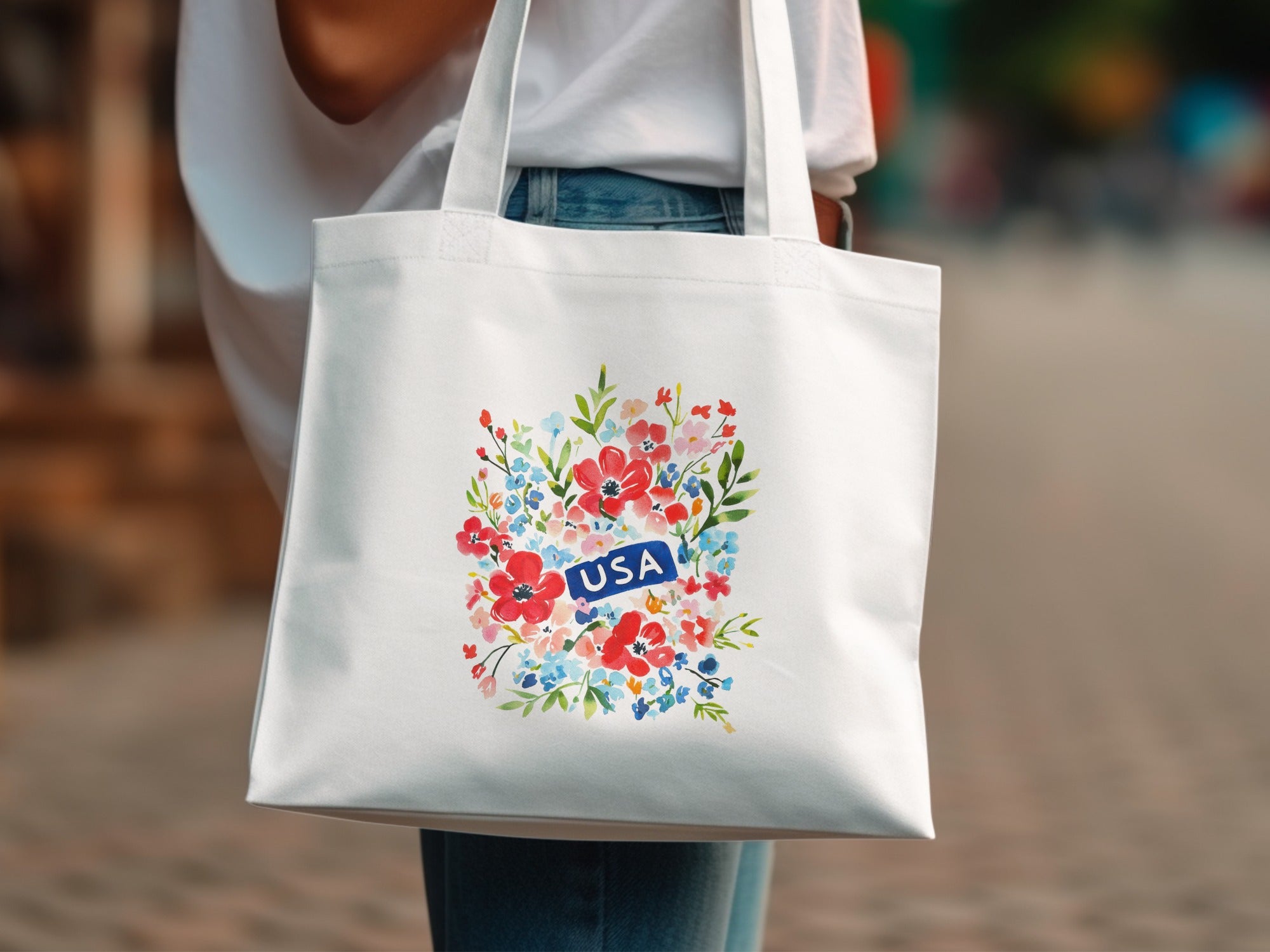 White tote bag with colorful floral print and "USA" banner.