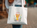 White tote bag with a watercolor illustration of a beer glass surrounded by flowers.