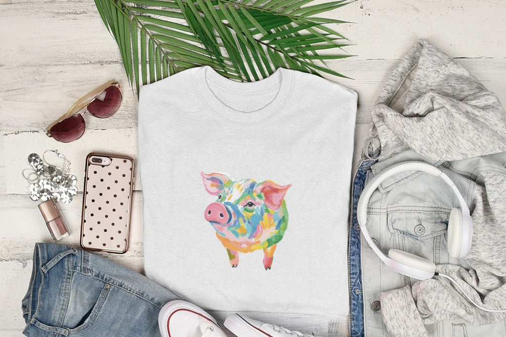 White t-shirt with colorful abstract pig graphic, laid flat with accessories.