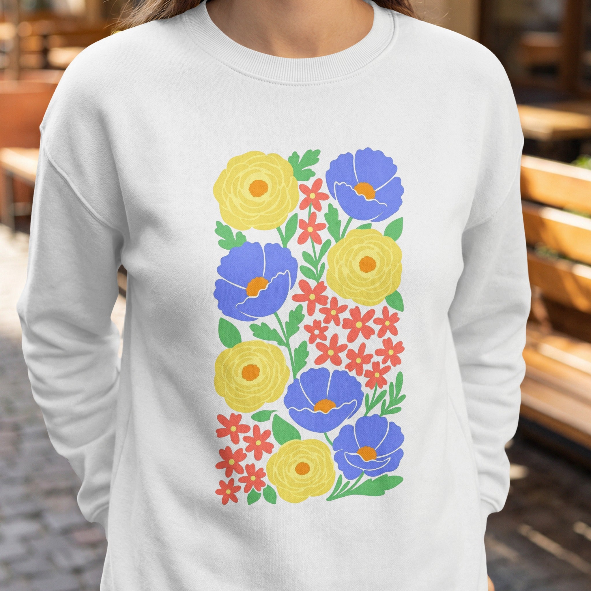 White sweatshirt with a vertical floral pattern of blue, yellow, and red flowers.