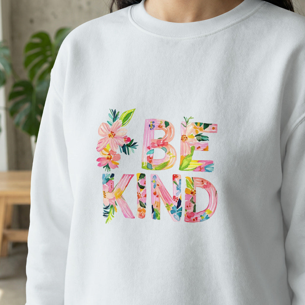 White sweatshirt with colorful floral "BE KIND" lettering.