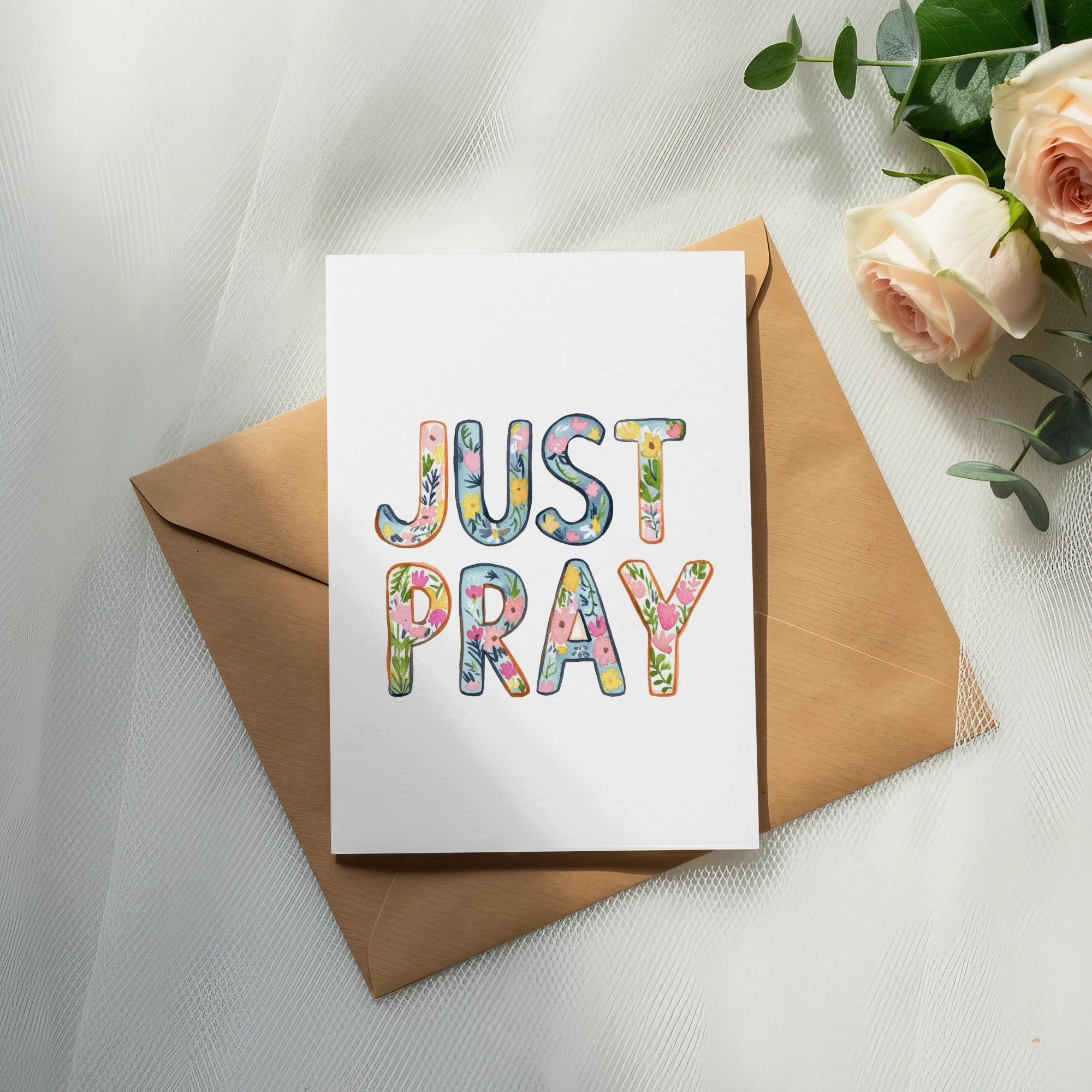 Card with "JUST PRAY" text in floral lettering on an envelope.