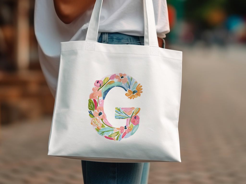 White tote bag with a floral letter G design.
