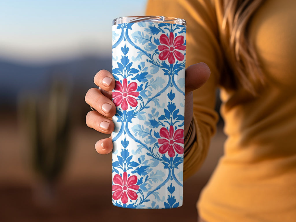 Tumbler with blue floral pattern and red flowers.