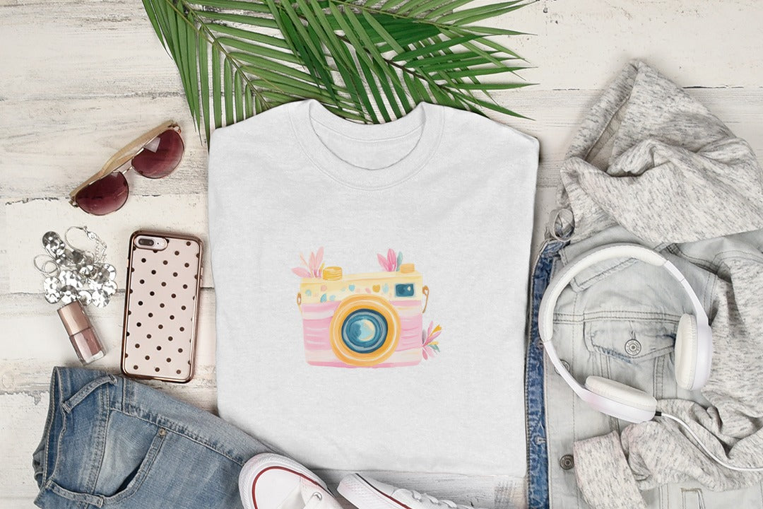 White t-shirt with a colorful, retro camera graphic and floral accents.