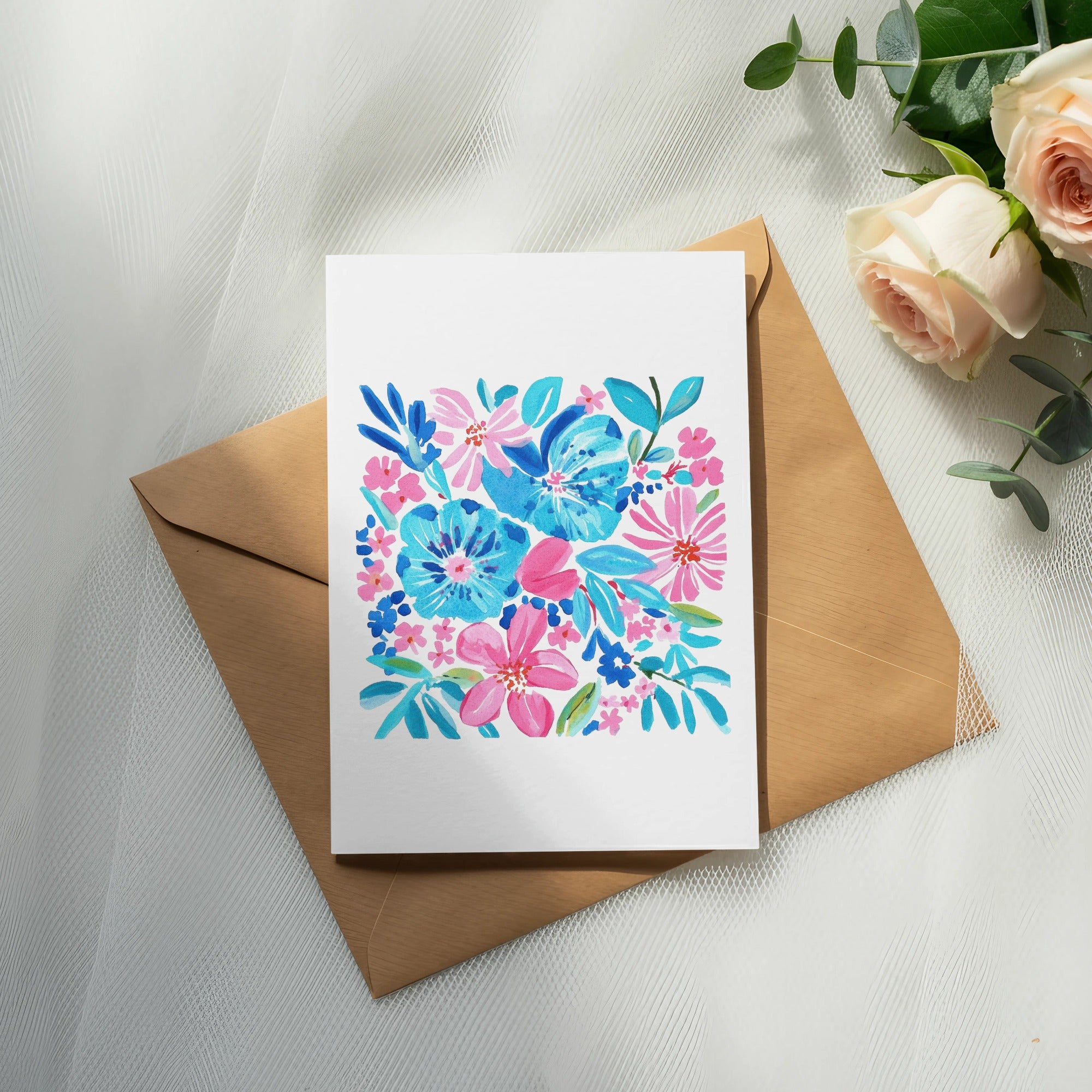 Watercolor floral greeting card on brown envelope, with roses and eucalyptus.
