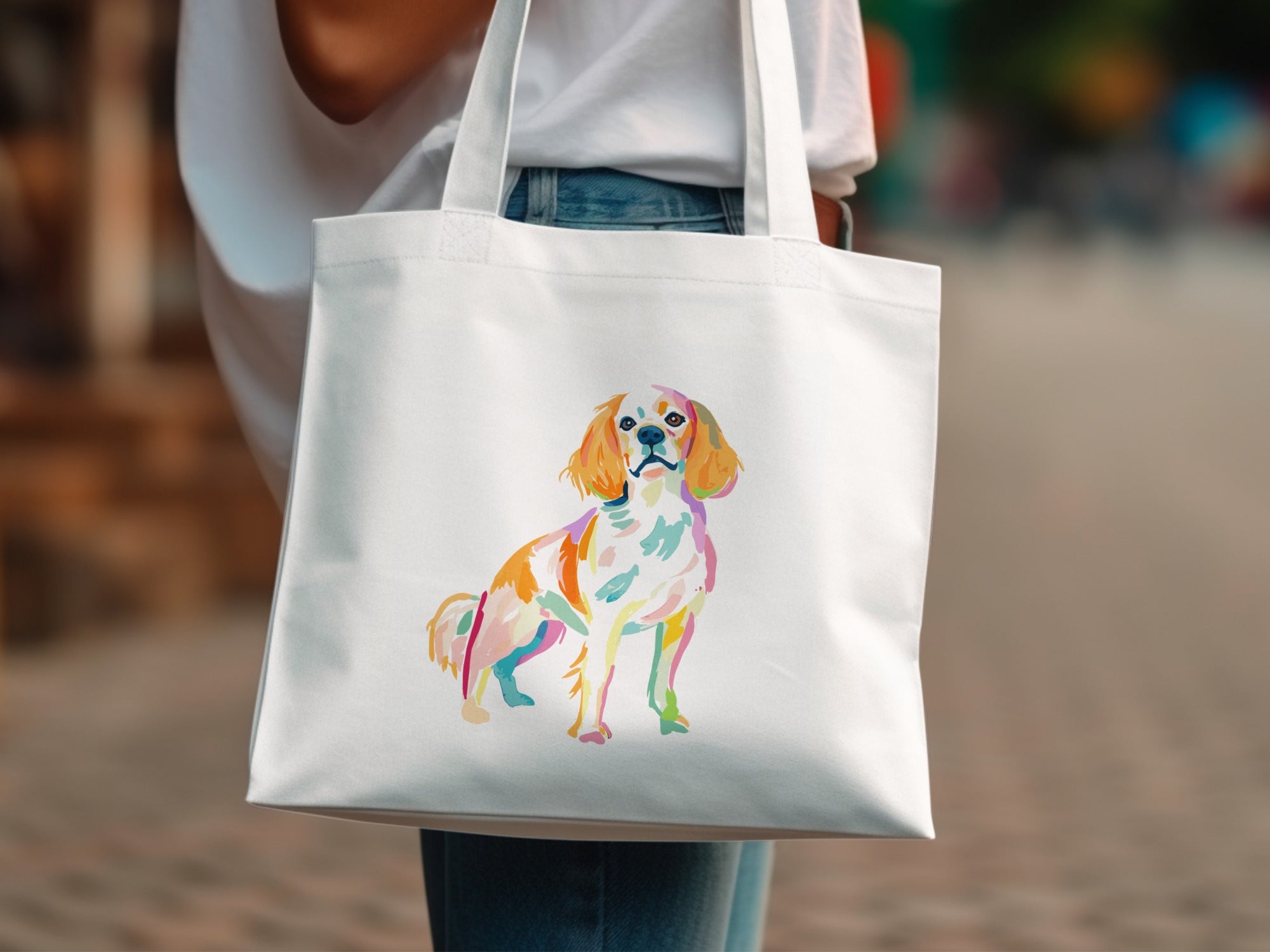 White tote bag with colorful watercolor painting of a Cavalier King Charles Spaniel dog.