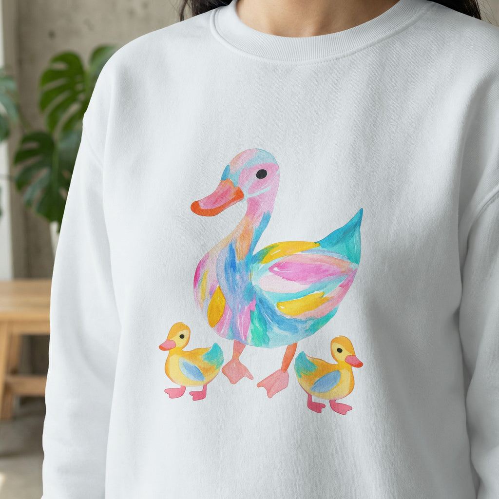 Watercolor duck family with colorful abstract patterns on a white sweatshirt.