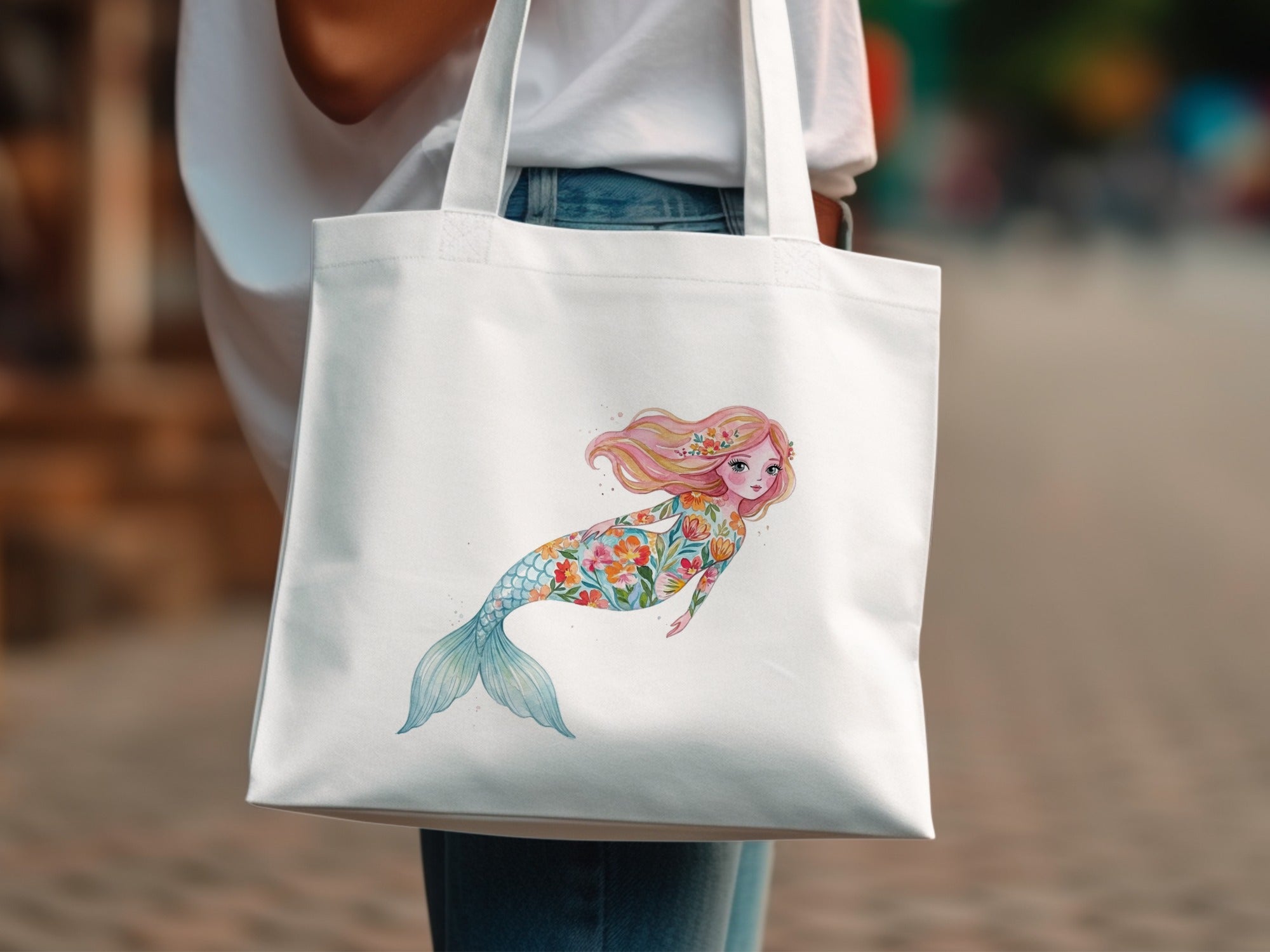White tote bag with a floral mermaid illustration.