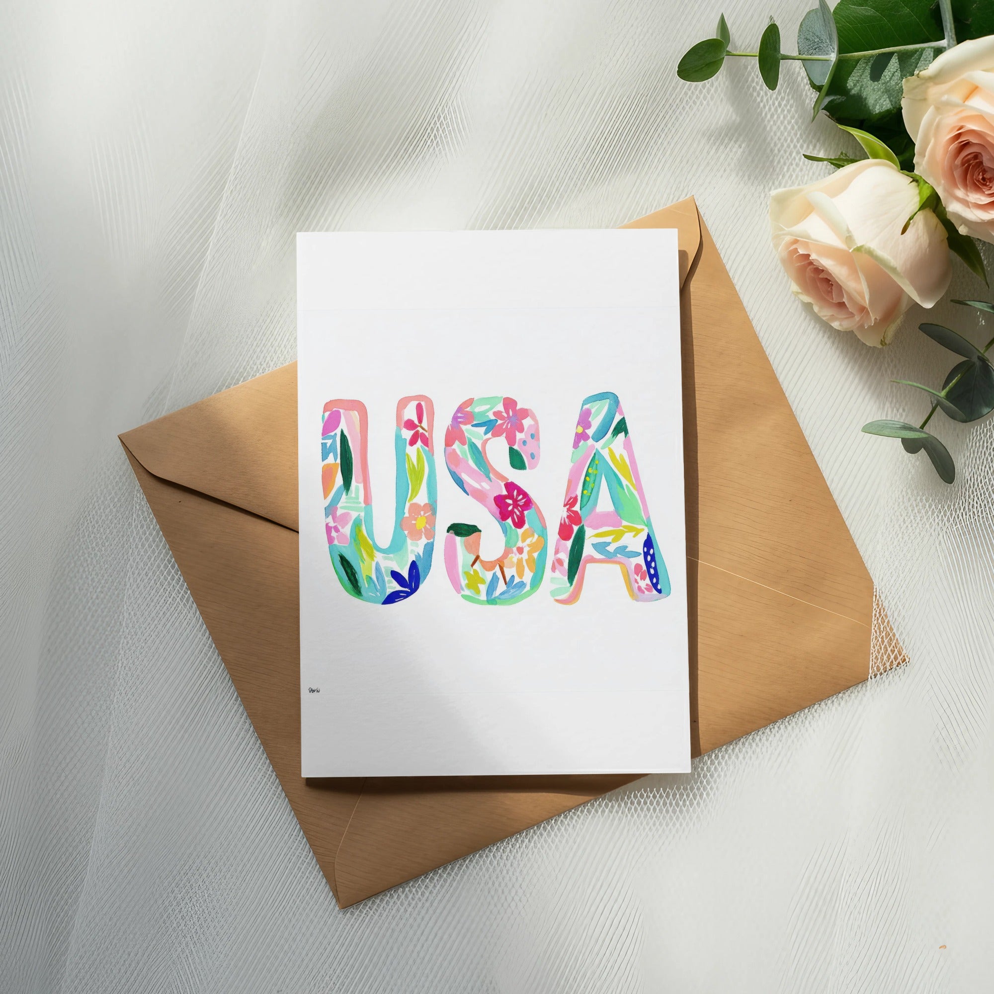 Card with colorful "USA" text on a brown envelope, with roses.