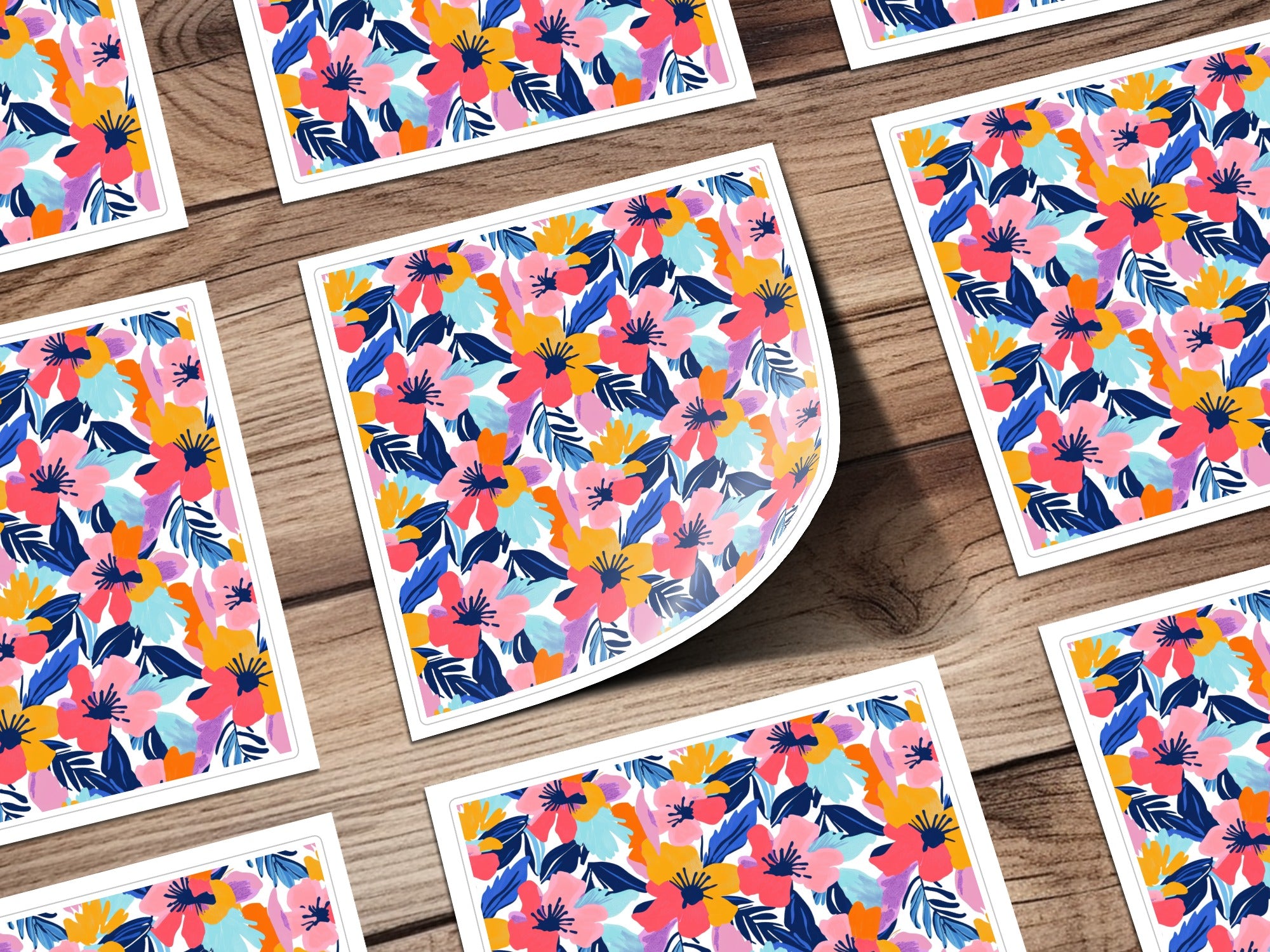Floral pattern on white cards scattered on a wooden surface.