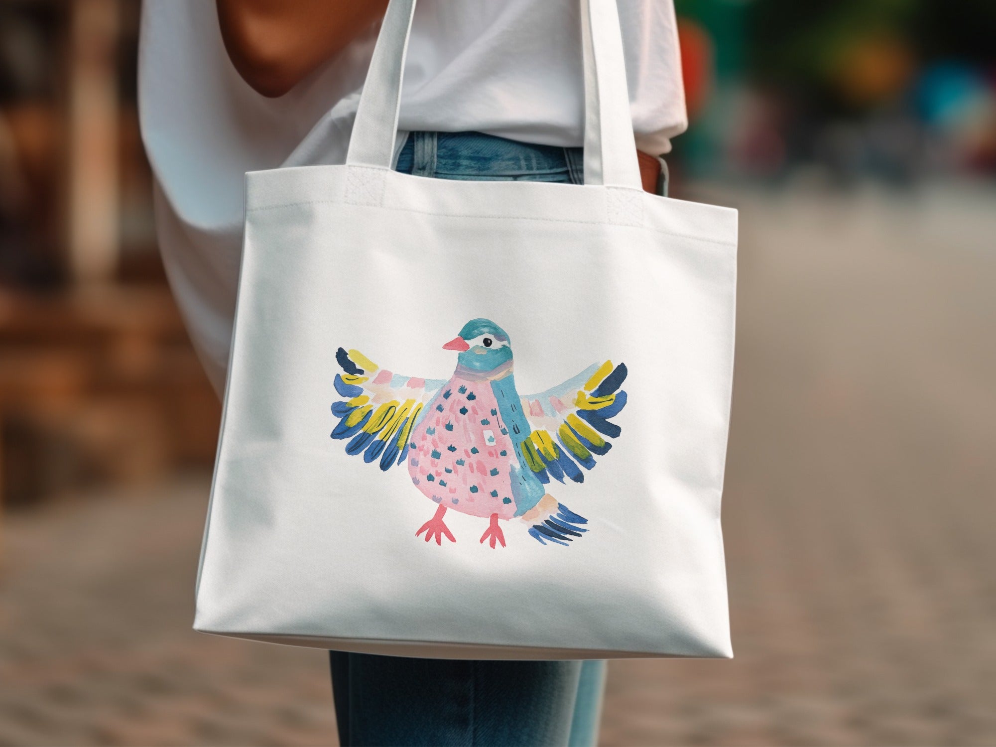 White tote bag with colorful watercolor bird illustration.