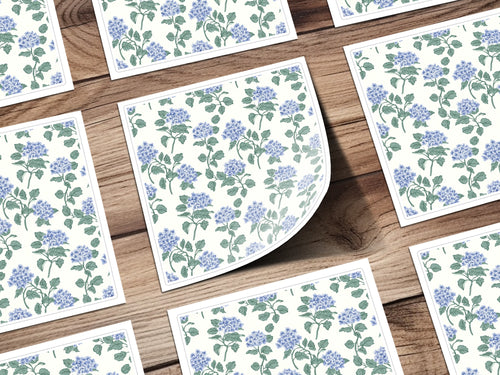 Floral patterned cards with blue flowers on a wooden background.
