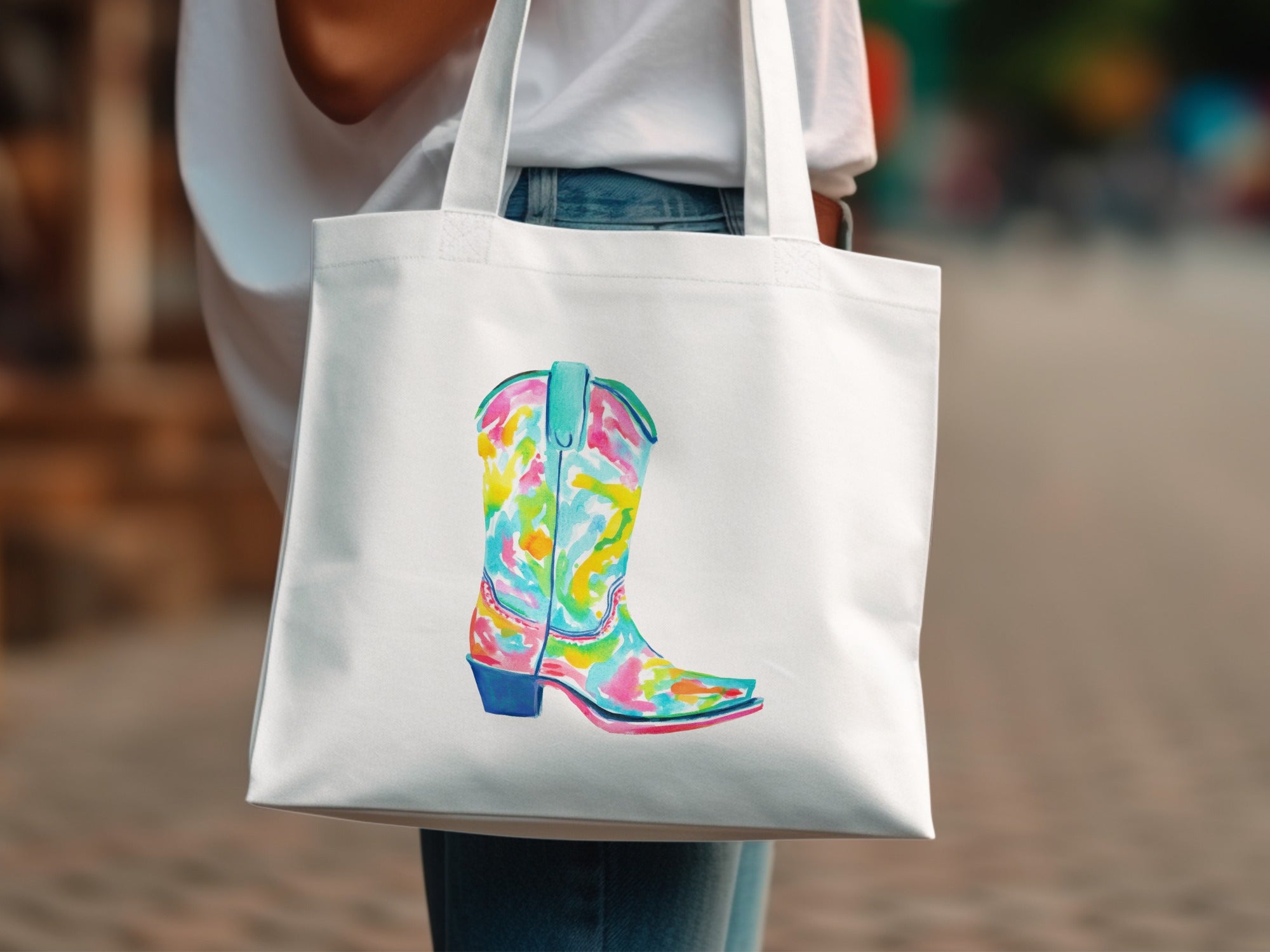 White tote bag with a colorful watercolor cowboy boot design.