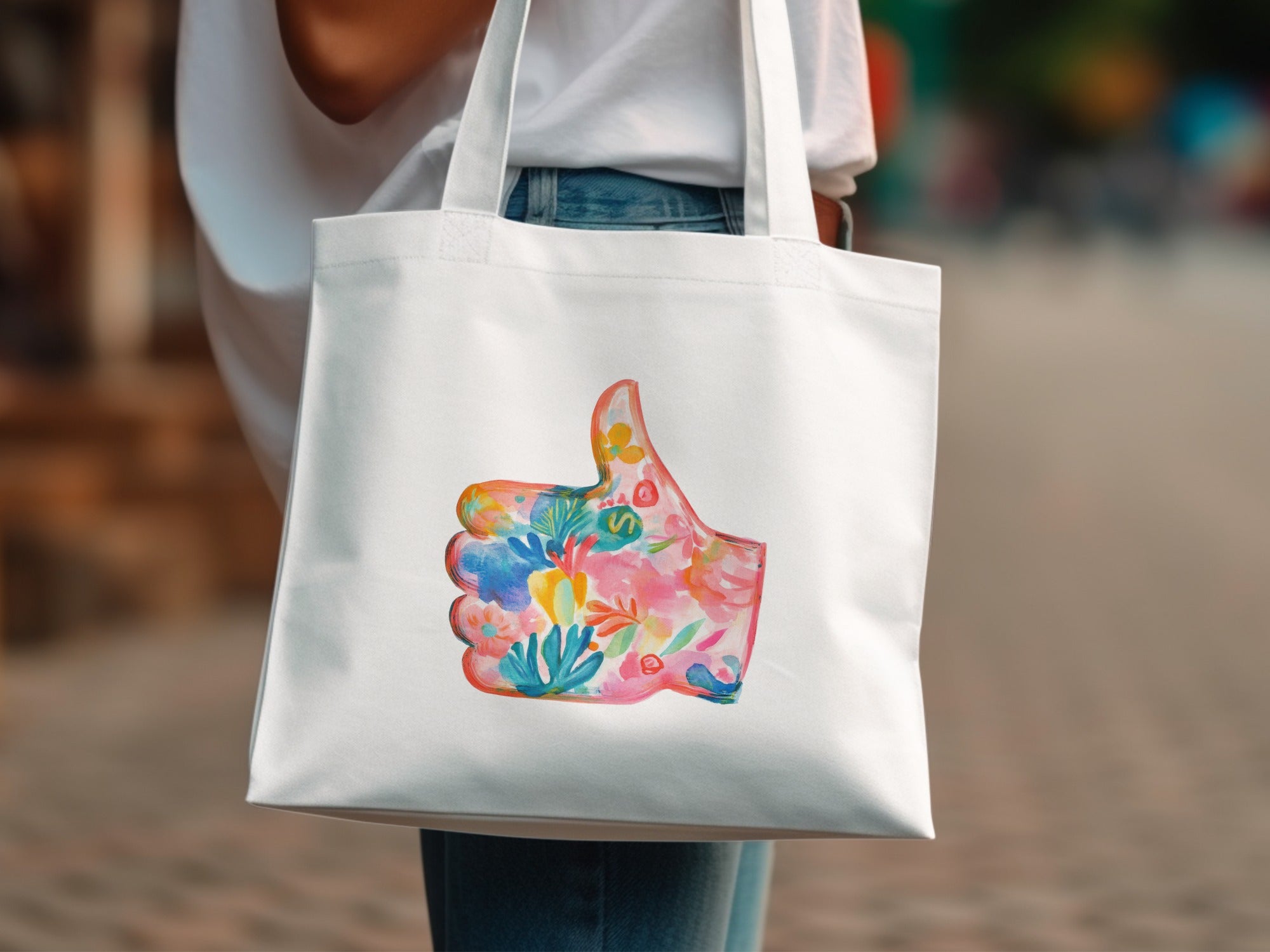 White tote bag with colorful floral thumbs-up design.