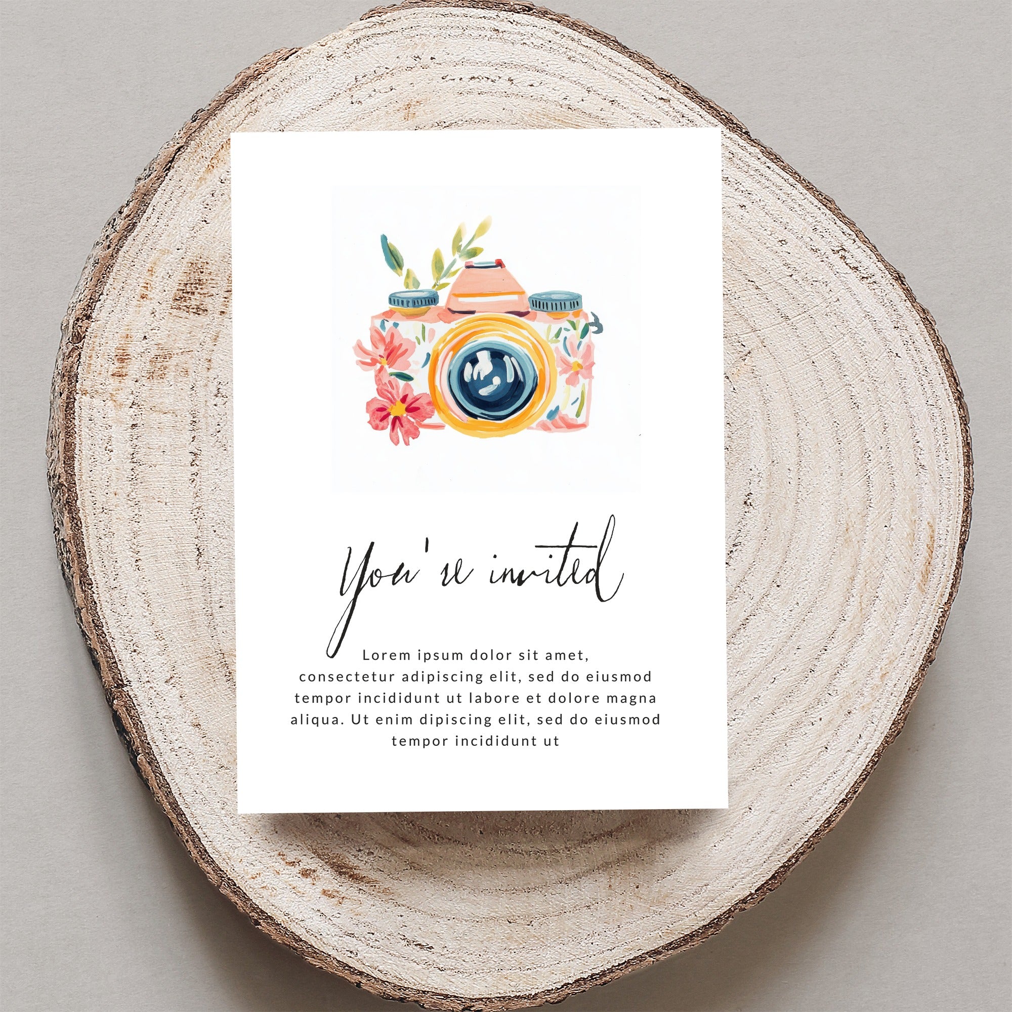 Watercolor camera invitation with floral accents and placeholder text.