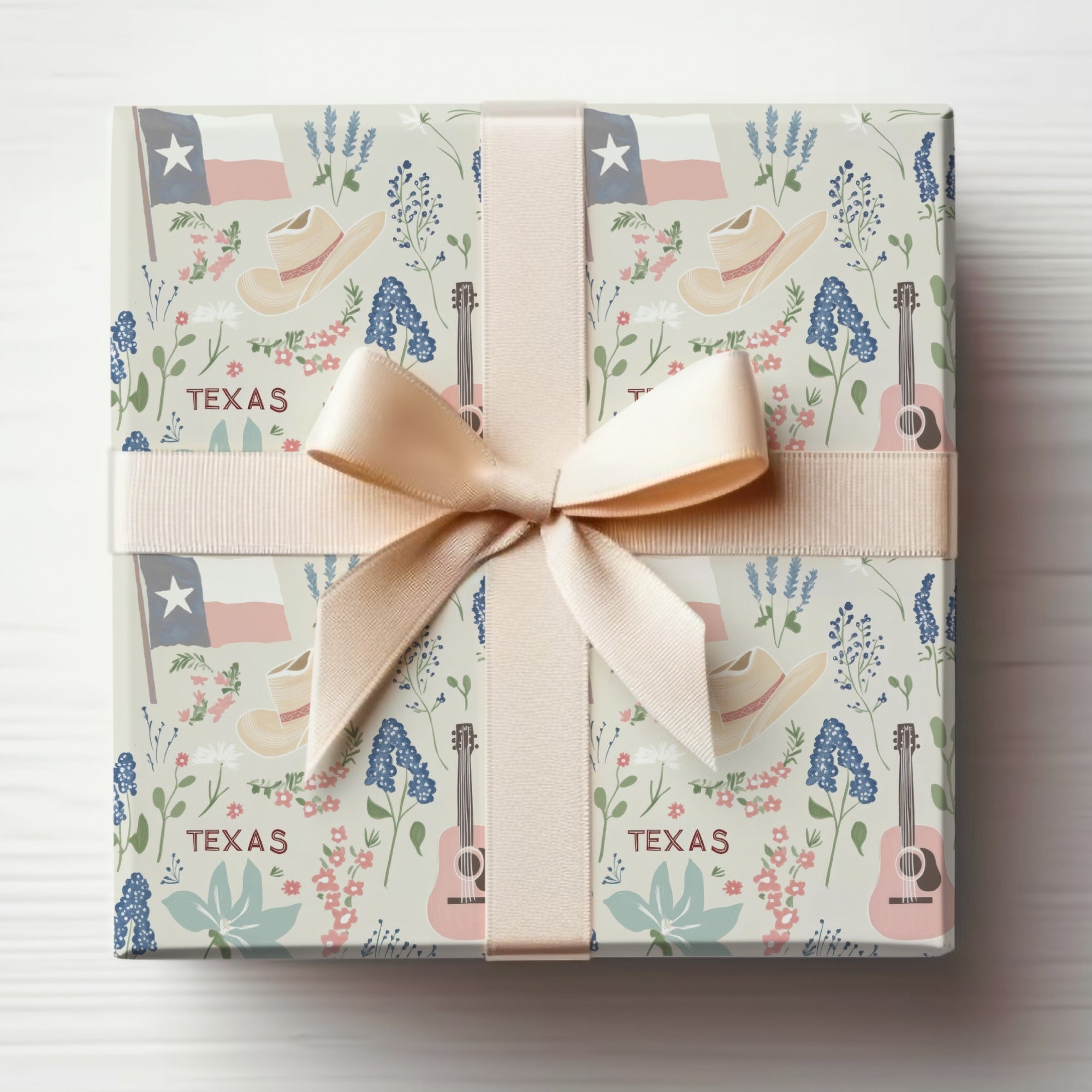 Wrapping paper with Texas motifs: flags, hats, guitars, and bluebonnets.