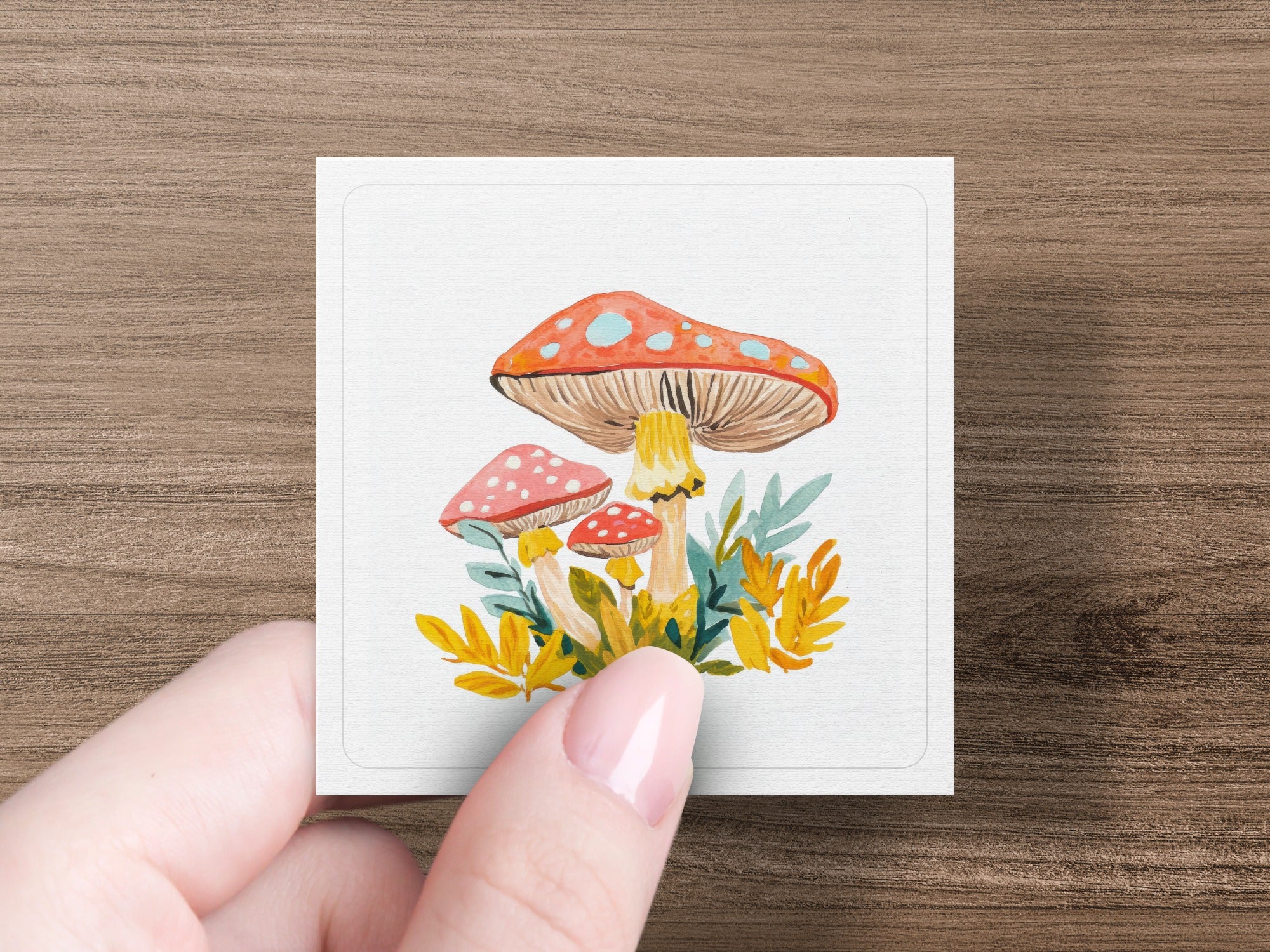 Watercolor illustration of three mushrooms with spotted caps and leaves.