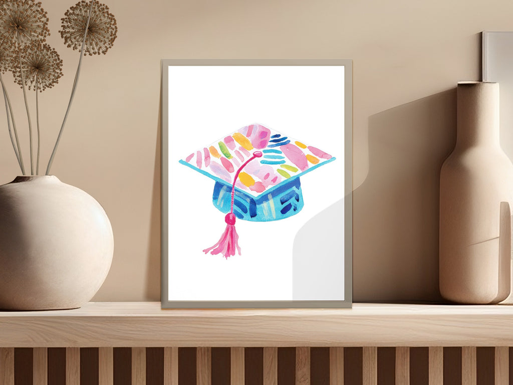 Watercolor graduation cap with pink tassel and colorful abstract brushstrokes.