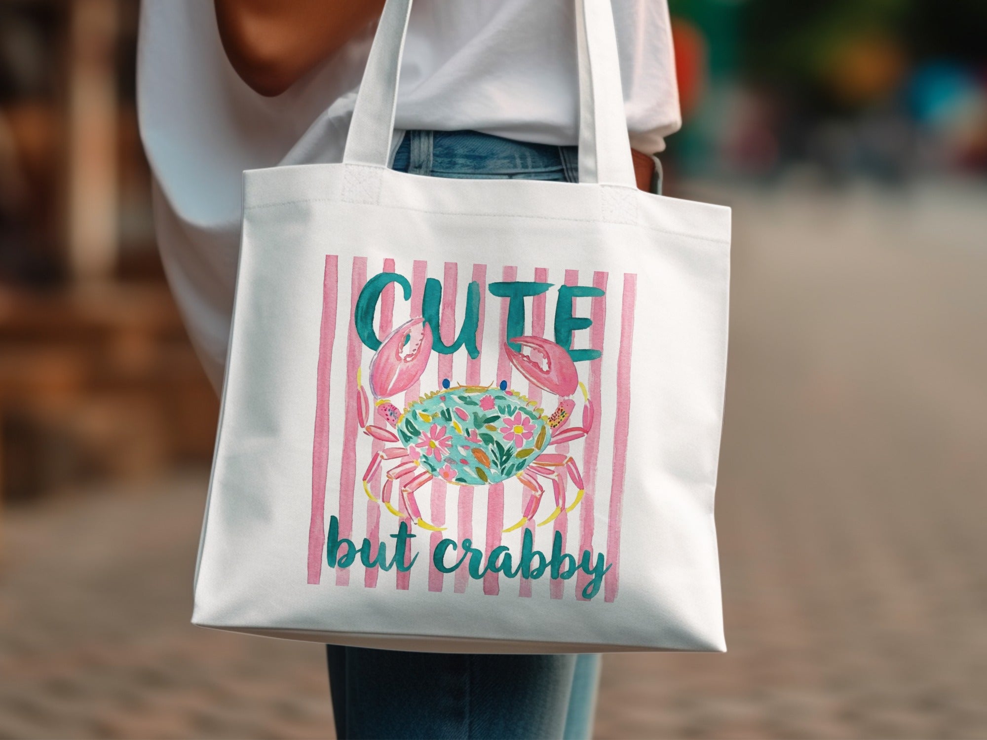 Tote bag with pink stripes and a watercolor crab with flowers.