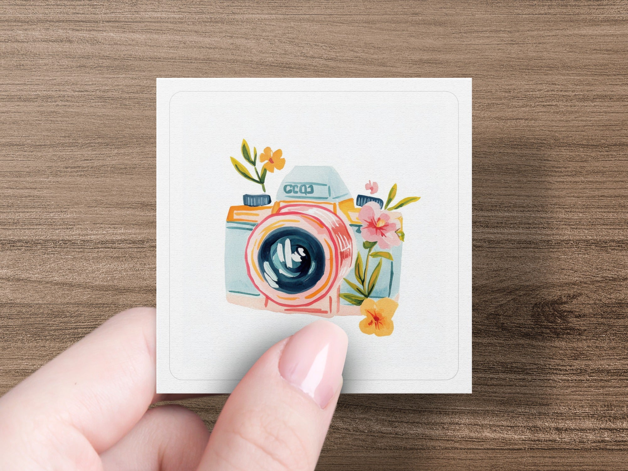 Watercolor camera illustration with flowers and leaves.