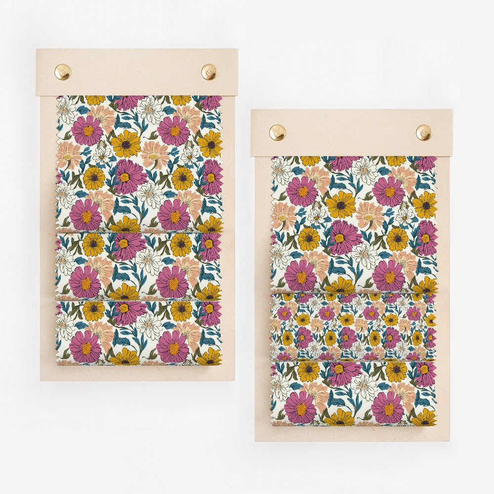 Two wooden notebooks display a floral pattern of pink, yellow, and purple flowers.