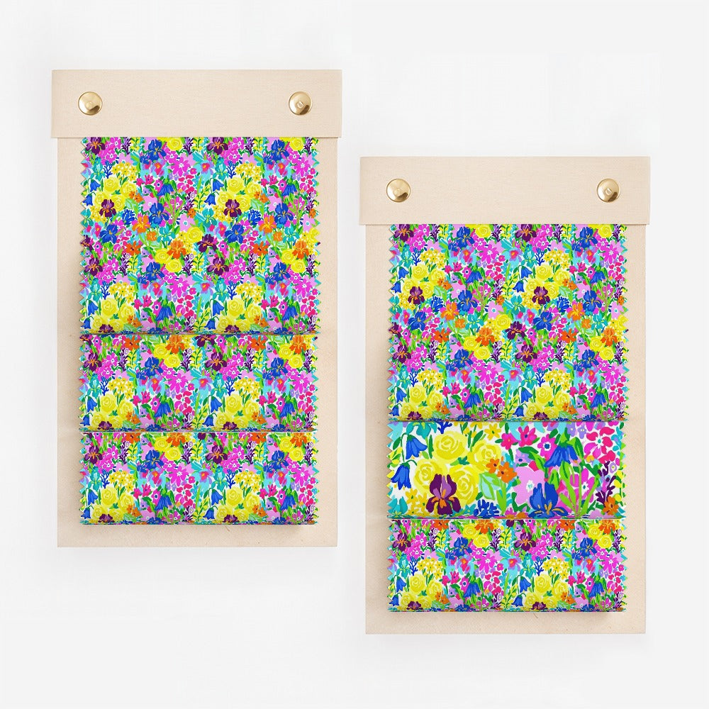 Two swatches of colorful floral fabric on a wooden display board.