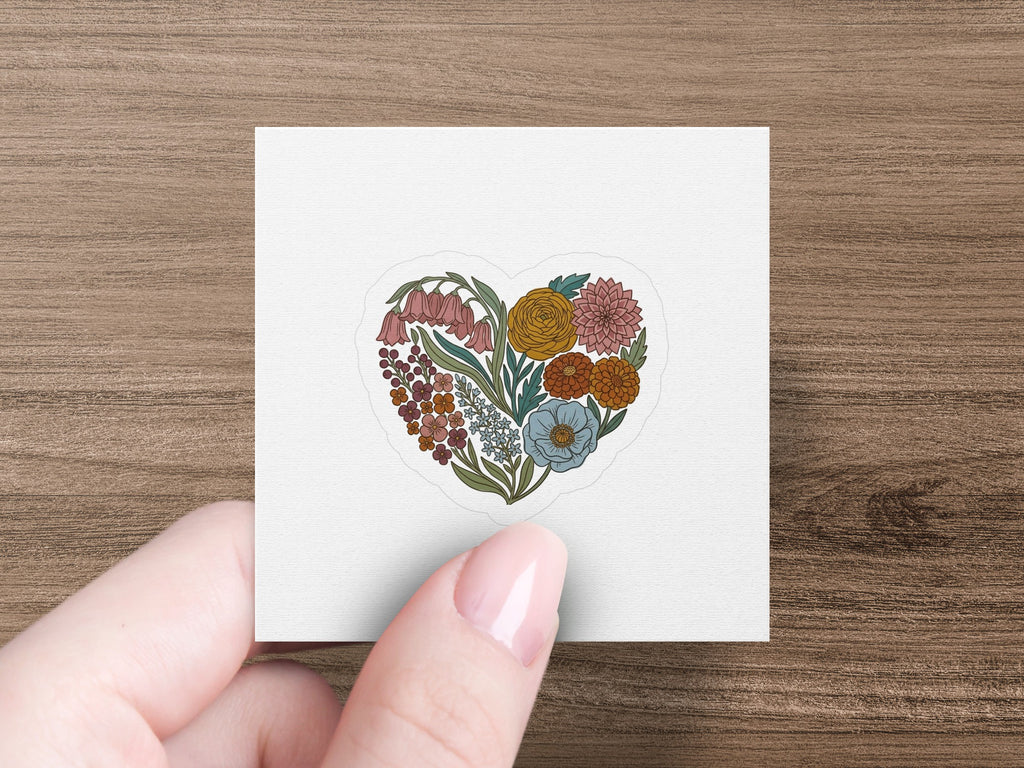Heart-shaped floral arrangement with various colorful flowers and greenery.