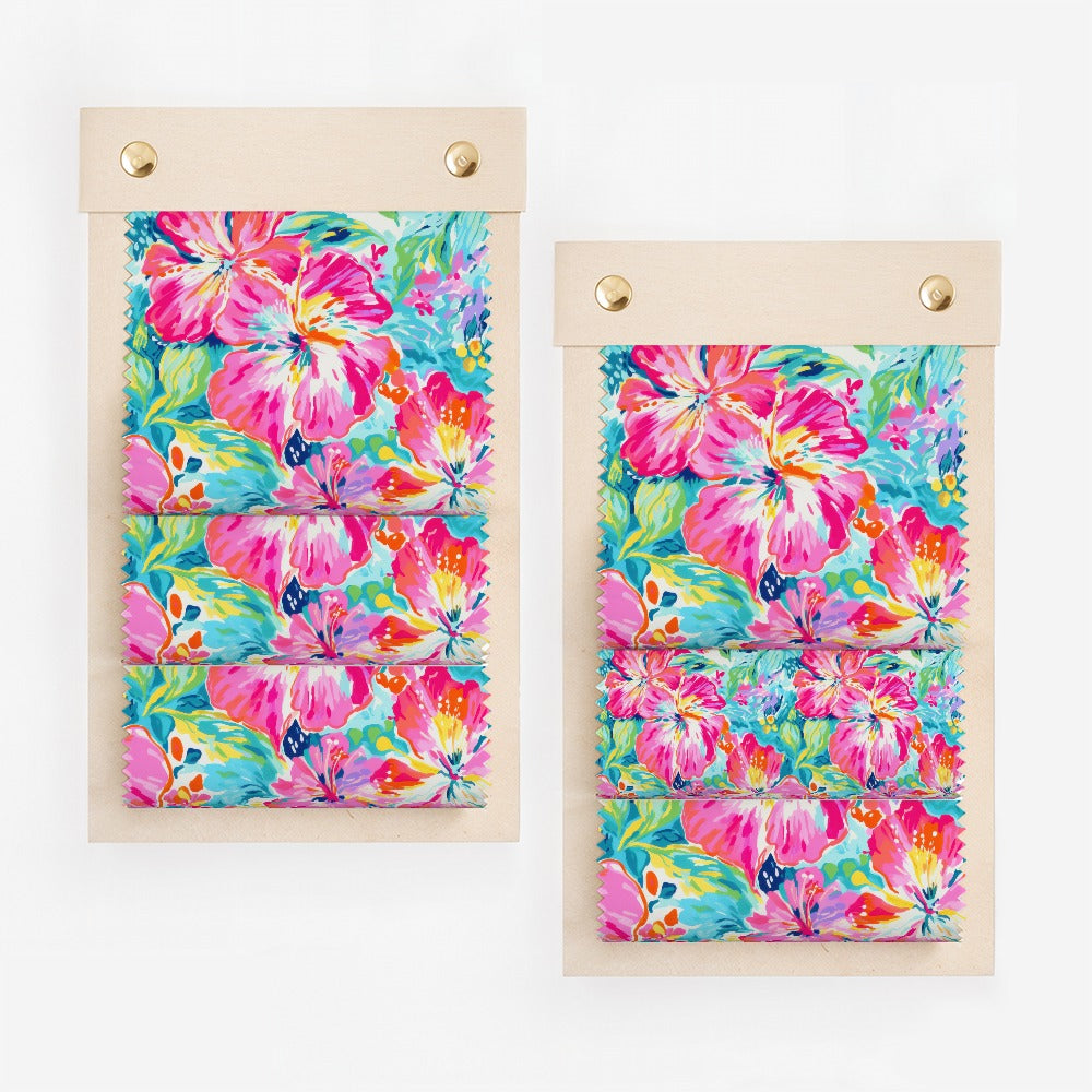 Two fabric swatch books displaying colorful floral hibiscus patterns.