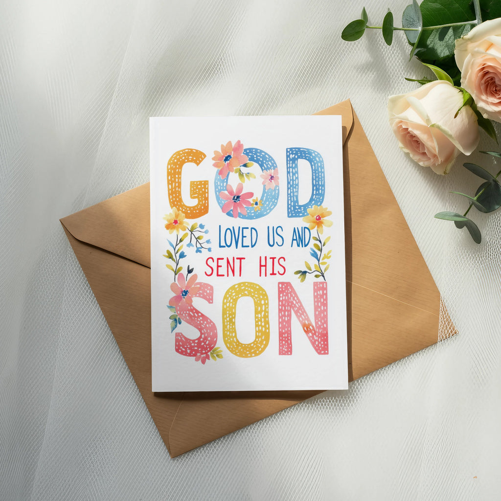 Greeting card with "God Loved Us and Sent His Son" message and floral accents.