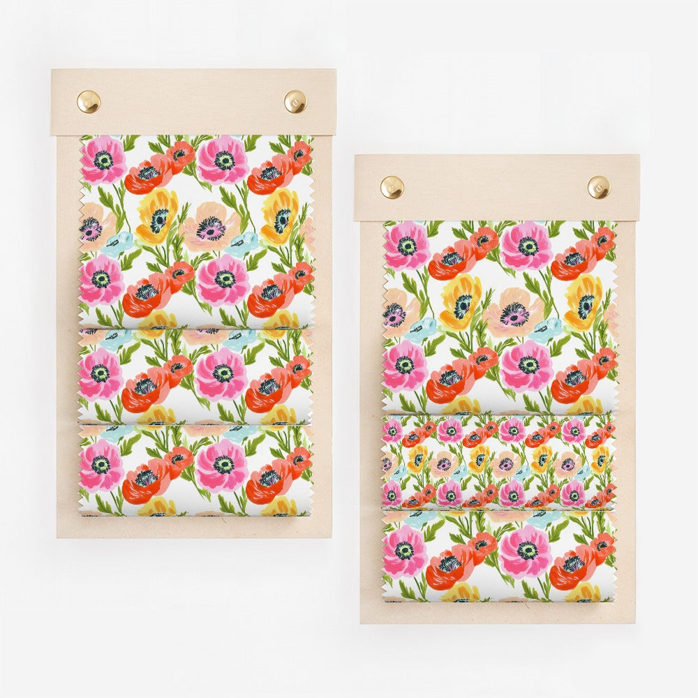 Fabric swatches with pink and yellow floral pattern on a wooden display.