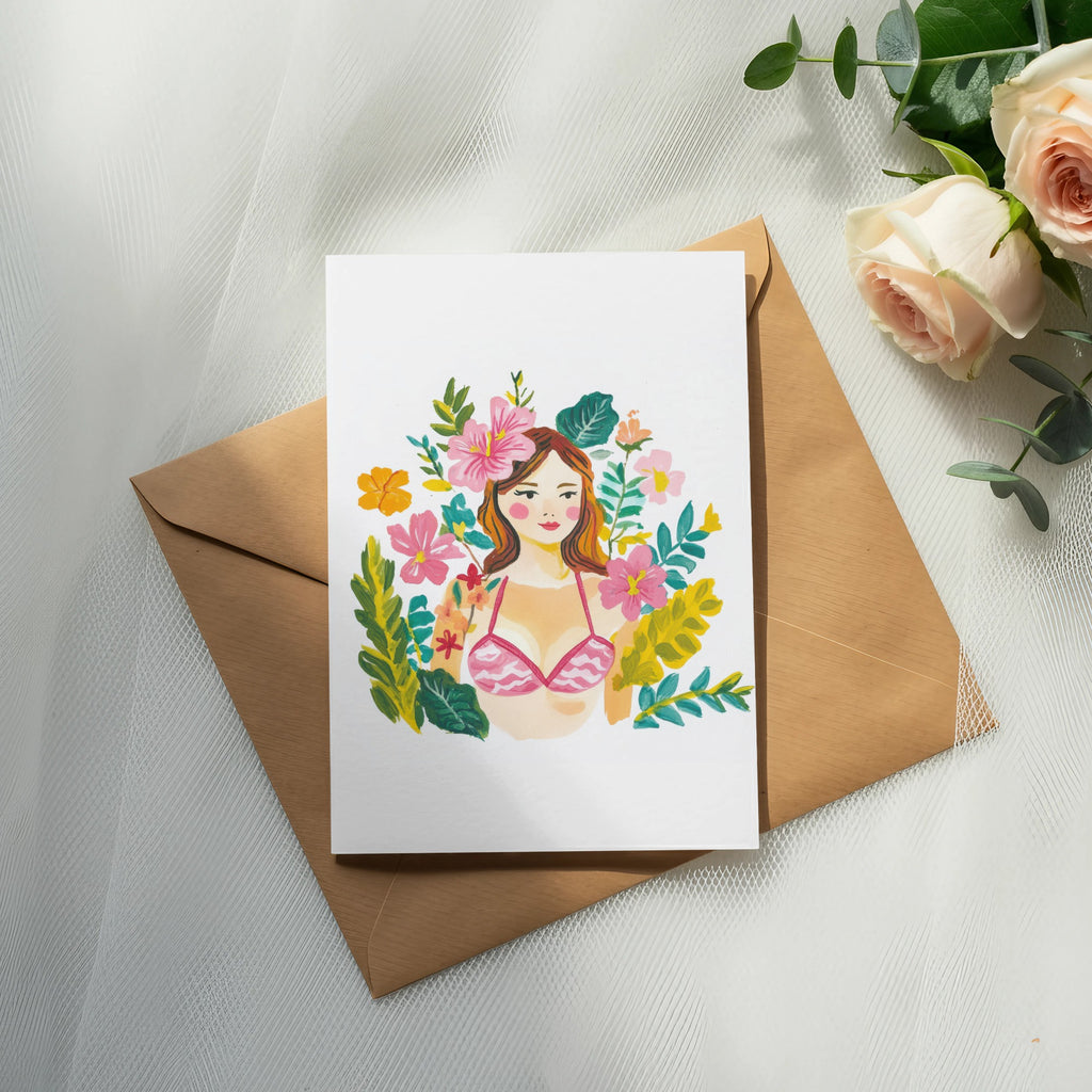 Watercolor illustration of a woman's face with flowers and foliage, on a card atop an envelope.